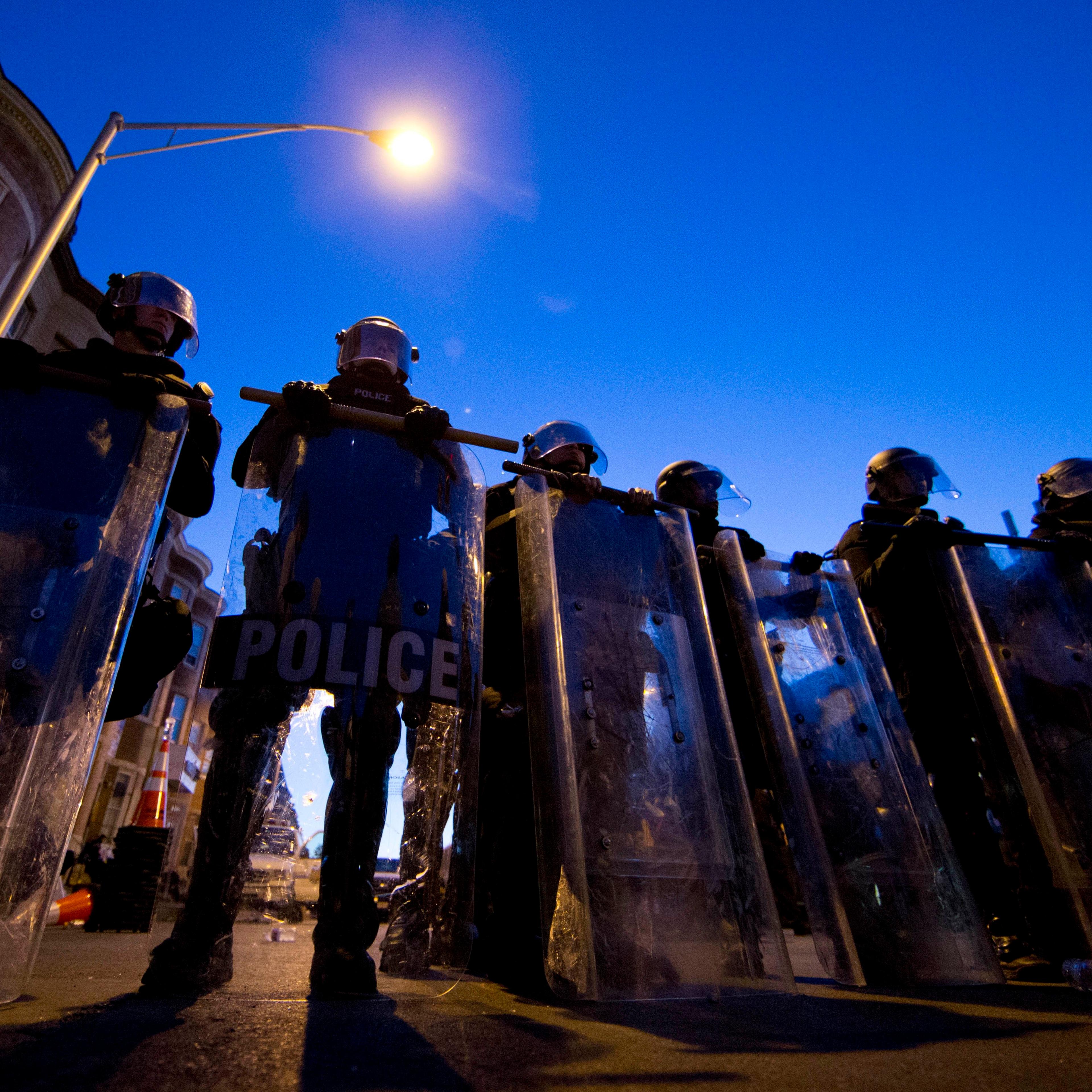 Police officers stand guard on April 28, 2015, in Baltimore.