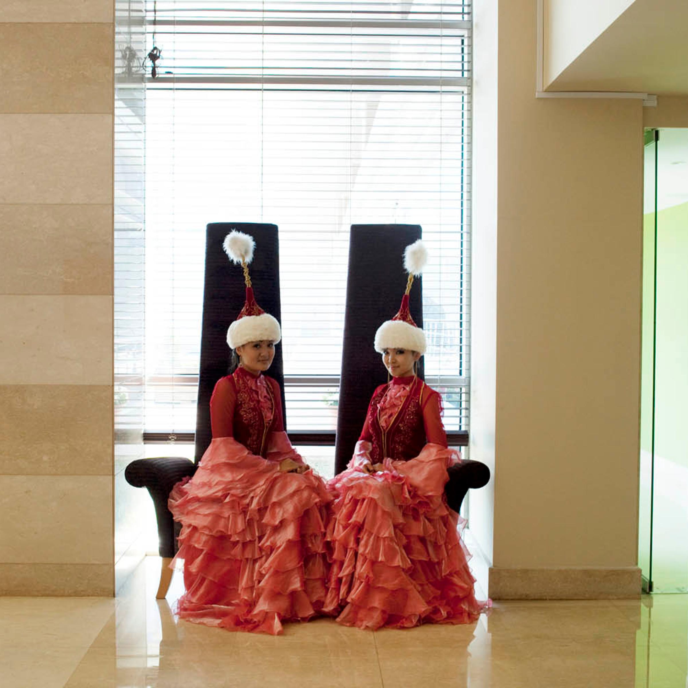 Women dressed in traditional Kazakh clothing sit waiting in the Renaissance hotel, where expat oil workers stay while visiting Atyrau on business.