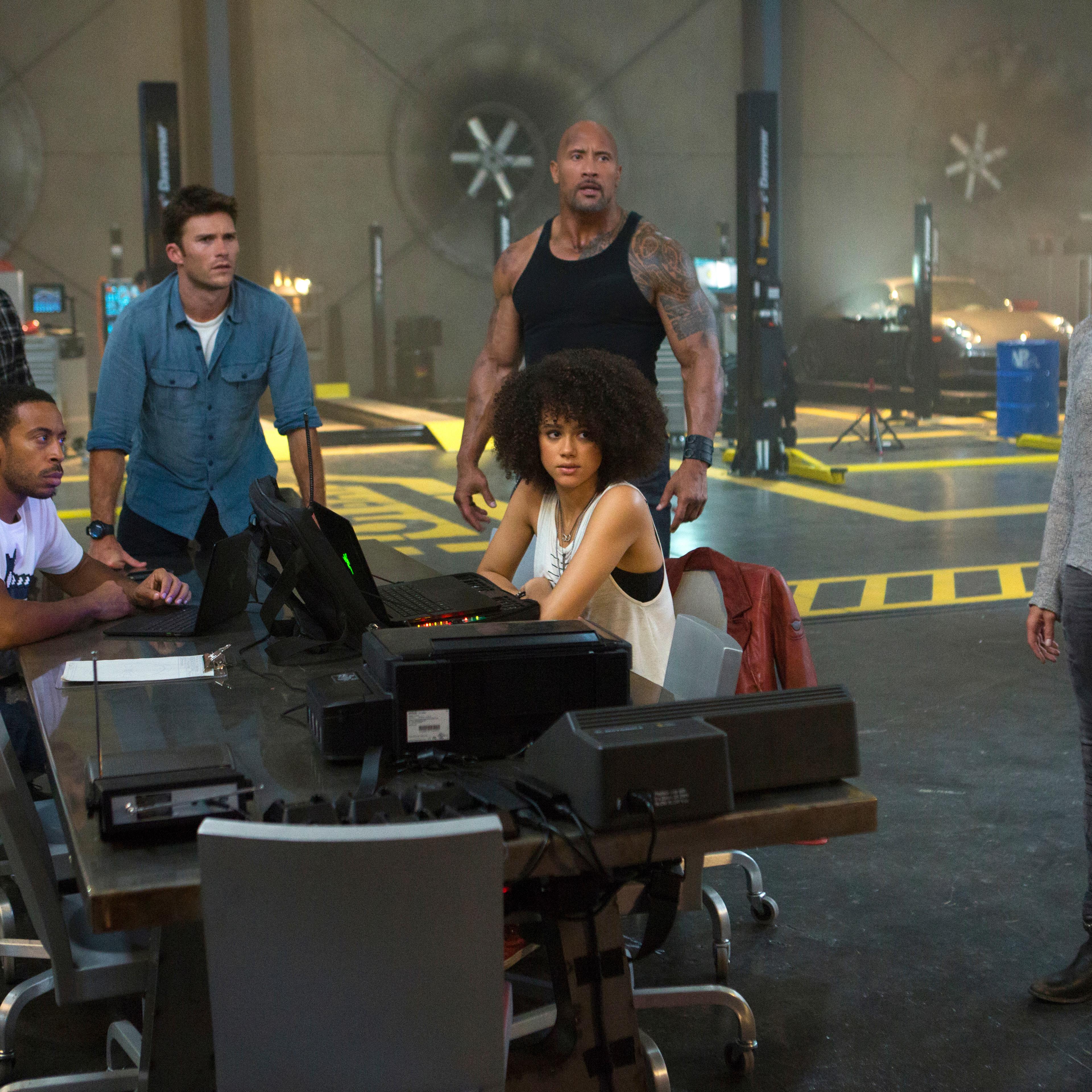 Chris "Ludacris" Bridges, seated left, and Nathalie Emmanuel, seated right, and Tyrese Gibson, standing from left, Scott Eastwood, Dwayne Johnson and Michelle Rodriguez in "The Fate of the Furious."