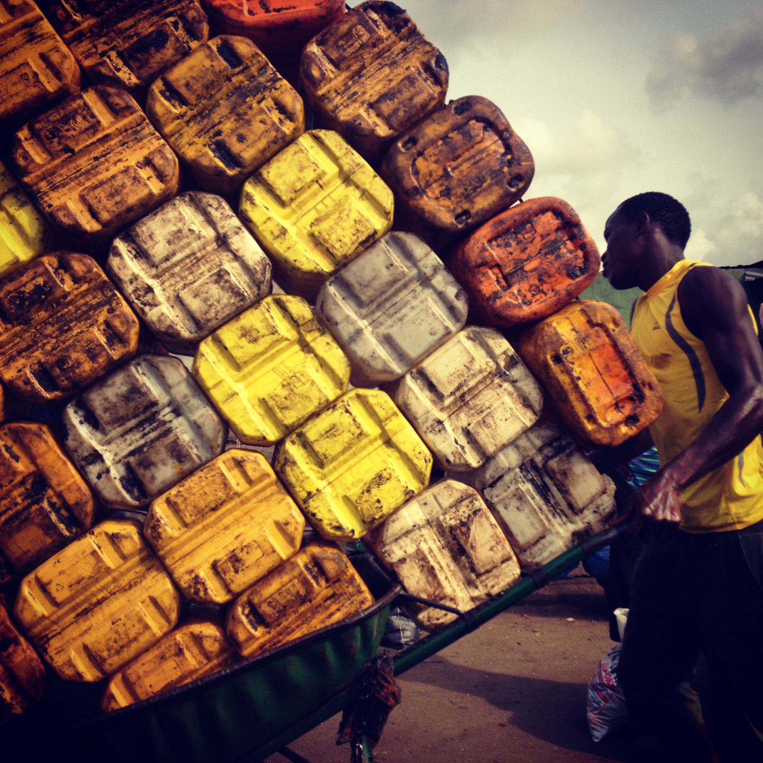 Apr. 6, 2014. <em>Lagos hustle: pushing plastic cans of palm oil at Mile 12 market</em> 