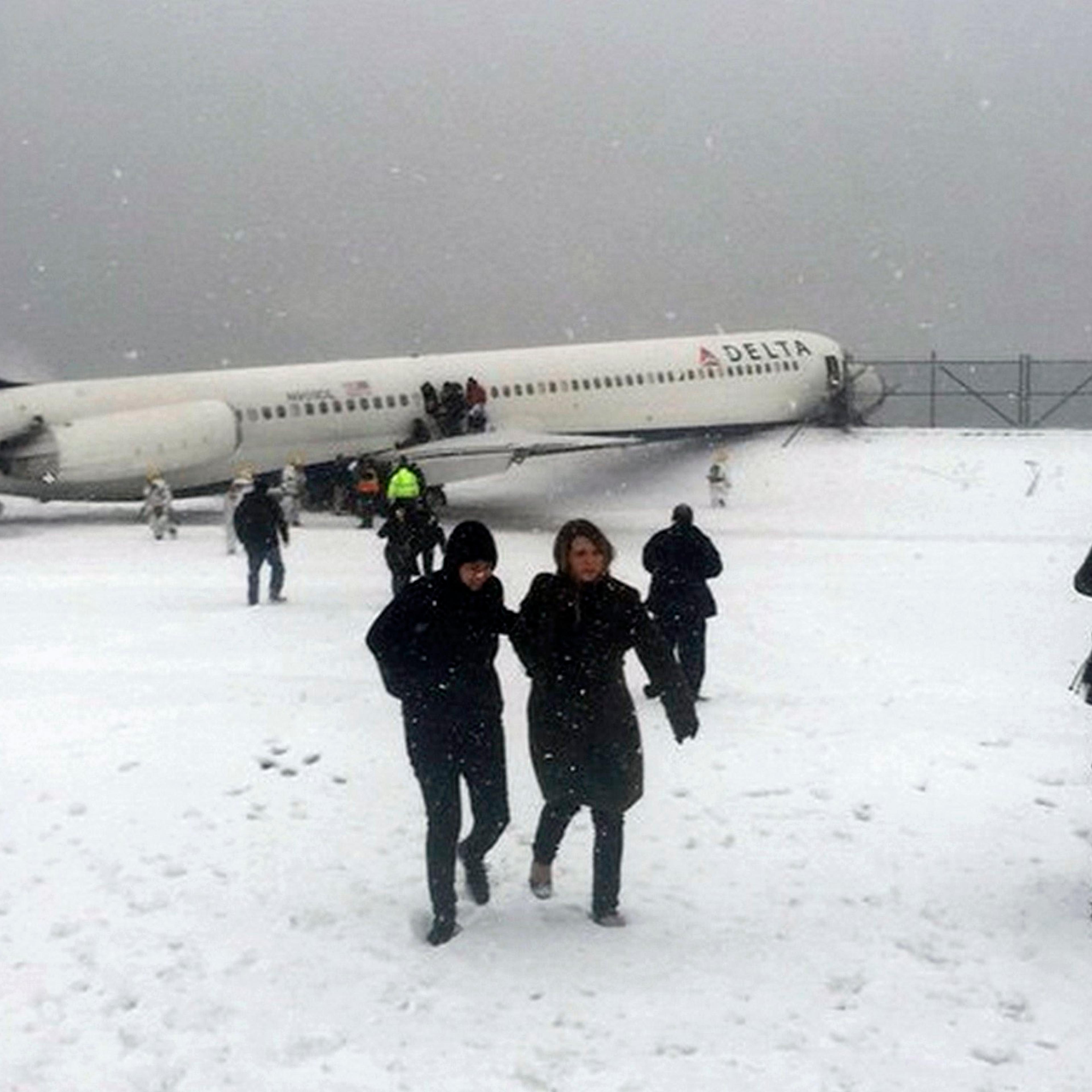 Passengers walk from a Delta jet which skidded off the runway at Laguardia airport in New York City on March 5, 2015.