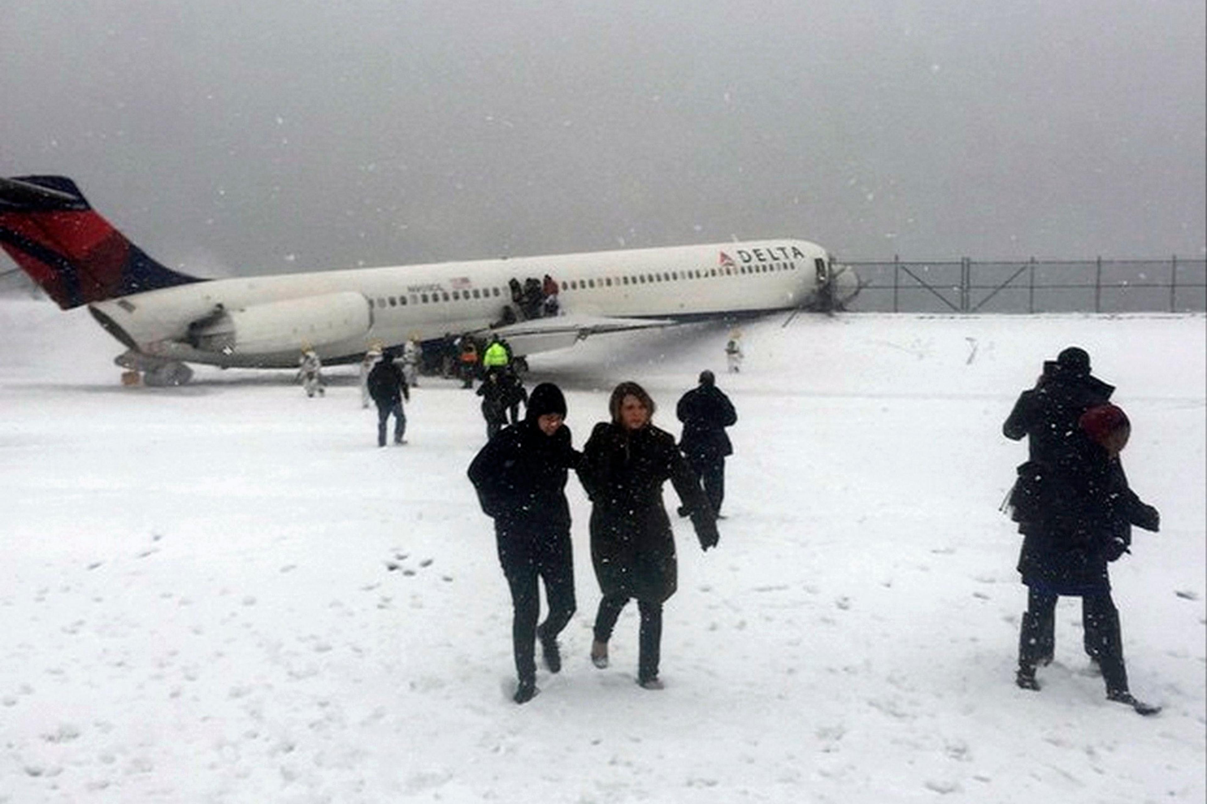 Passengers walk from a Delta jet which skidded off the runway at Laguardia airport in New York City on March 5, 2015.