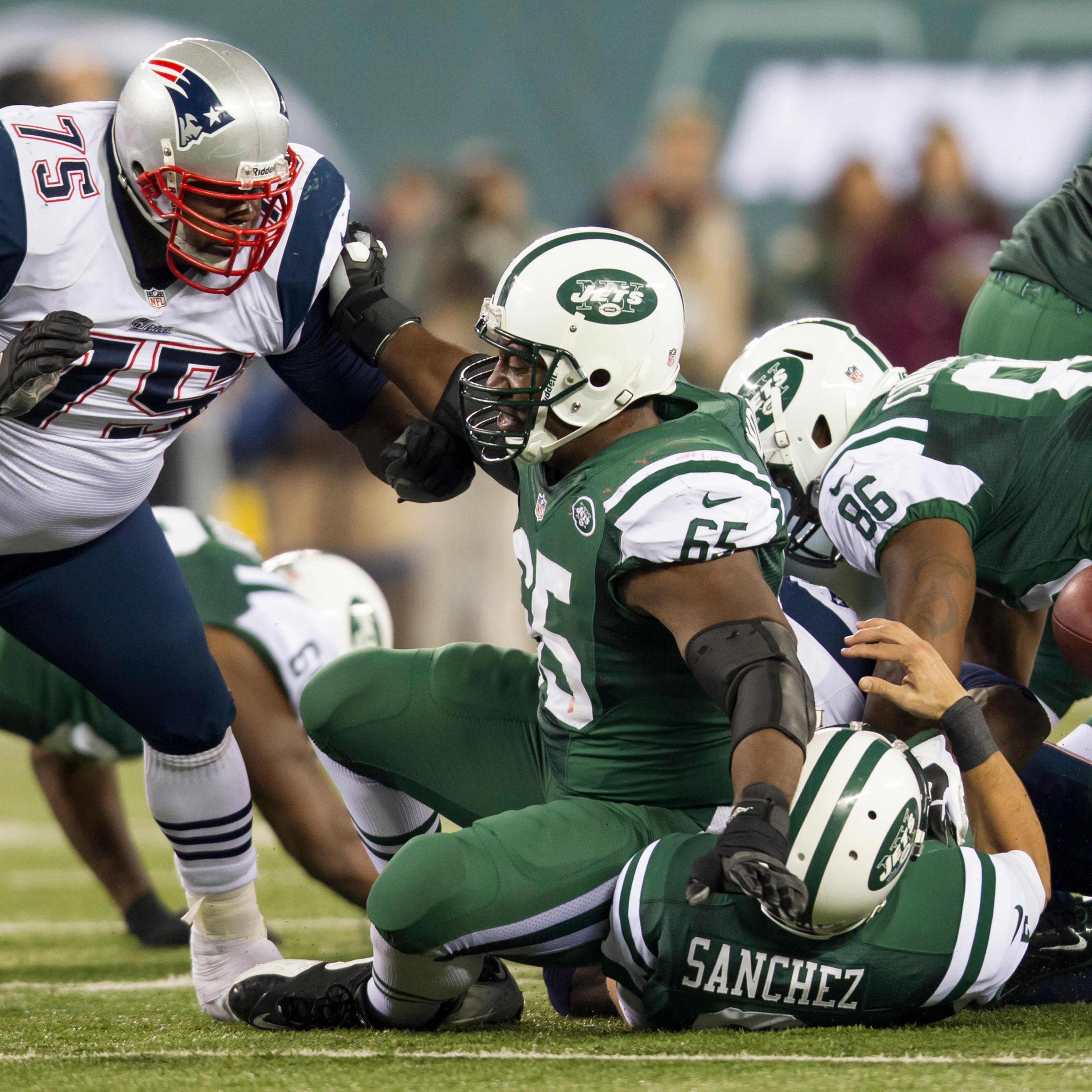 Patriots defensive tackle Vince Wilfork (75) pushes back New York Jets guard Brandon Moore (65) into quarterback Mark Sanchez (6) causing Sanchez to fumble the ball during the NFL Thanksgiving Day game between the New England Patriots and the New York Je