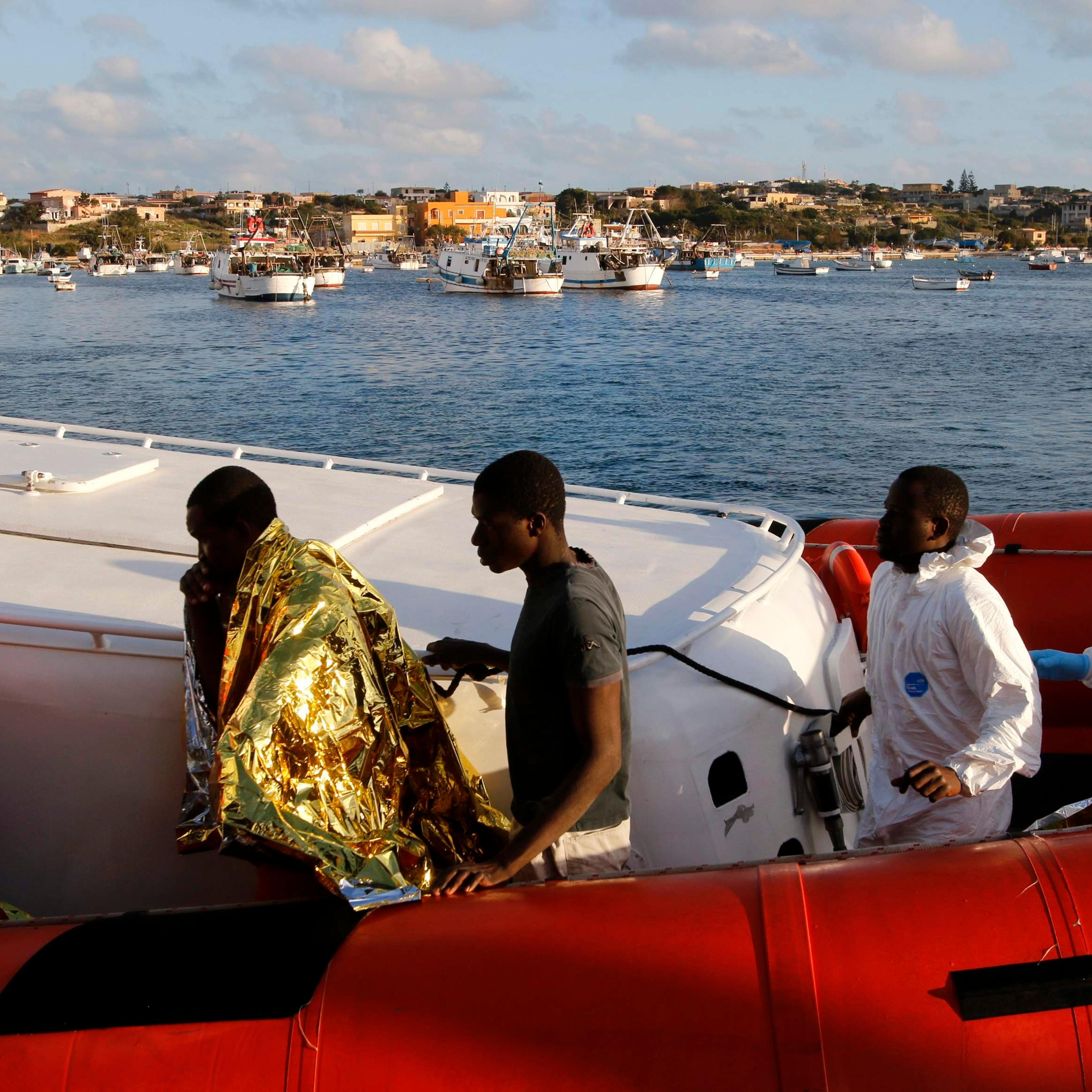 Migrants who survived a shipwreck arrive at the Lampedusa harbour