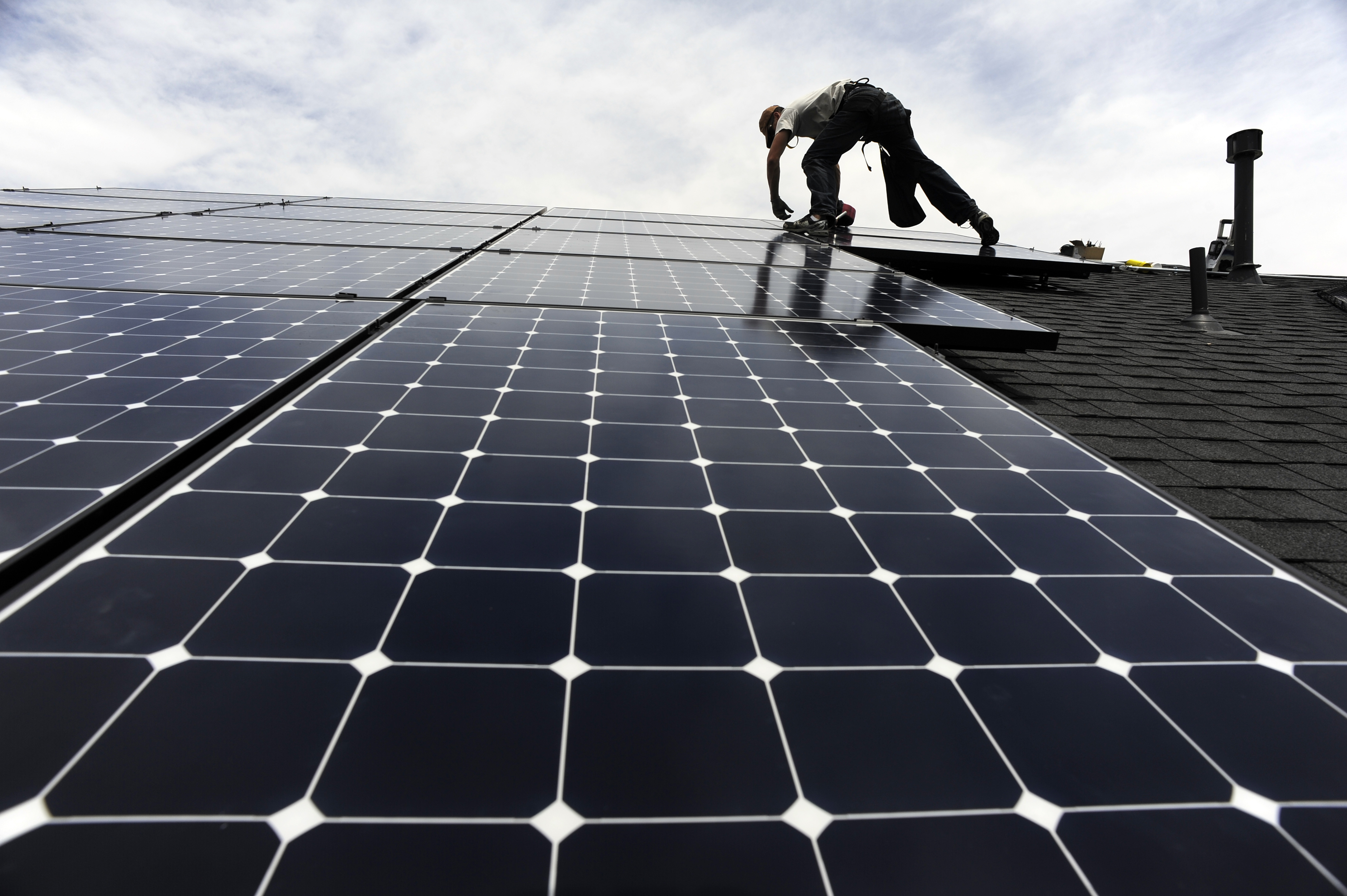 Solar installer, Justin Woodbury, Namaste (accent over the e) Solar, secures solar panels for a photovoltaic solar array system on the roof of a house in the Sorrel Ranch area, near e-470 and Smoky hill Road in Aurora Friday afternoon in record temperatu