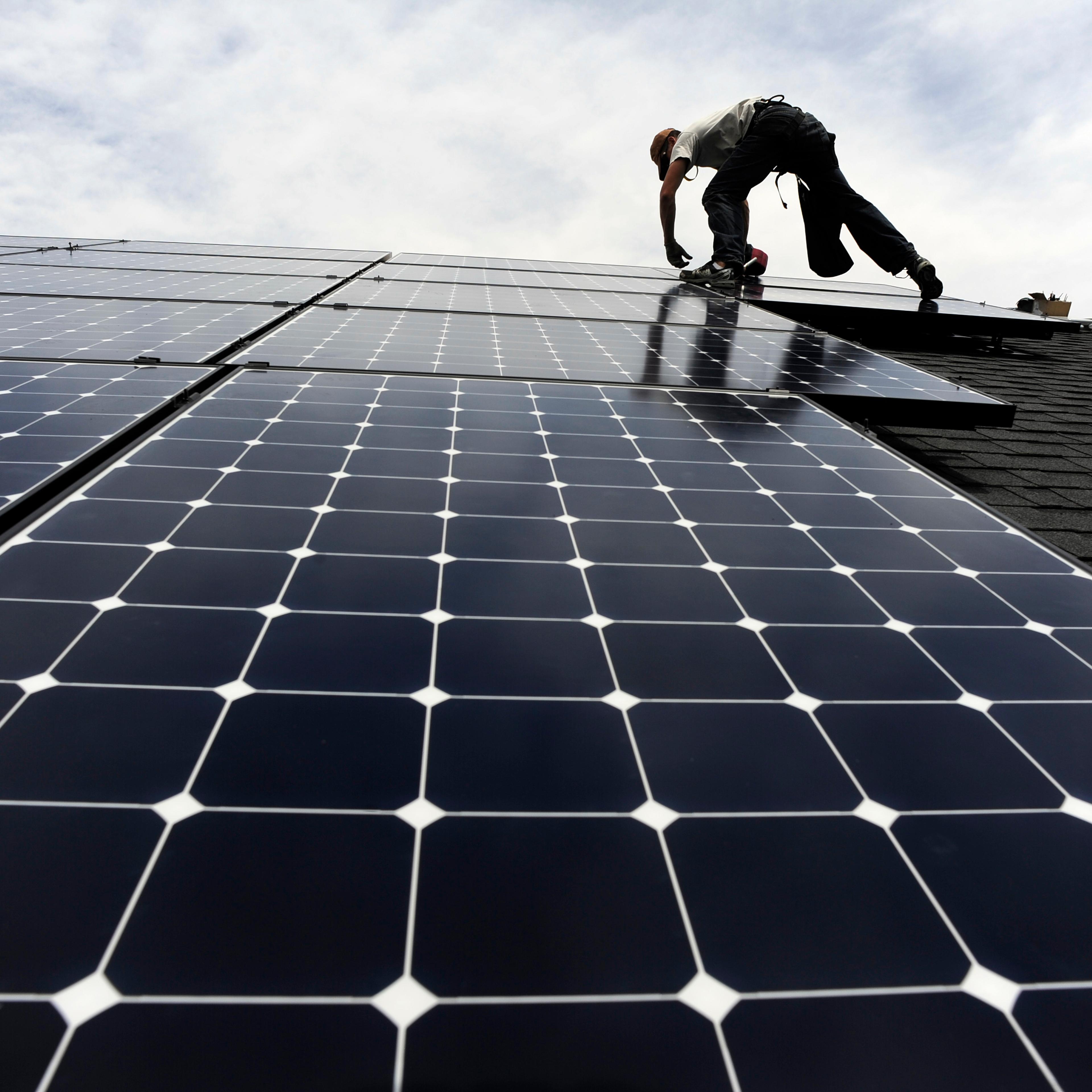 Solar installer, Justin Woodbury, Namaste (accent over the e) Solar, secures solar panels for a photovoltaic solar array system on the roof of a house in the Sorrel Ranch area, near e-470 and Smoky hill Road in Aurora Friday afternoon in record temperatu