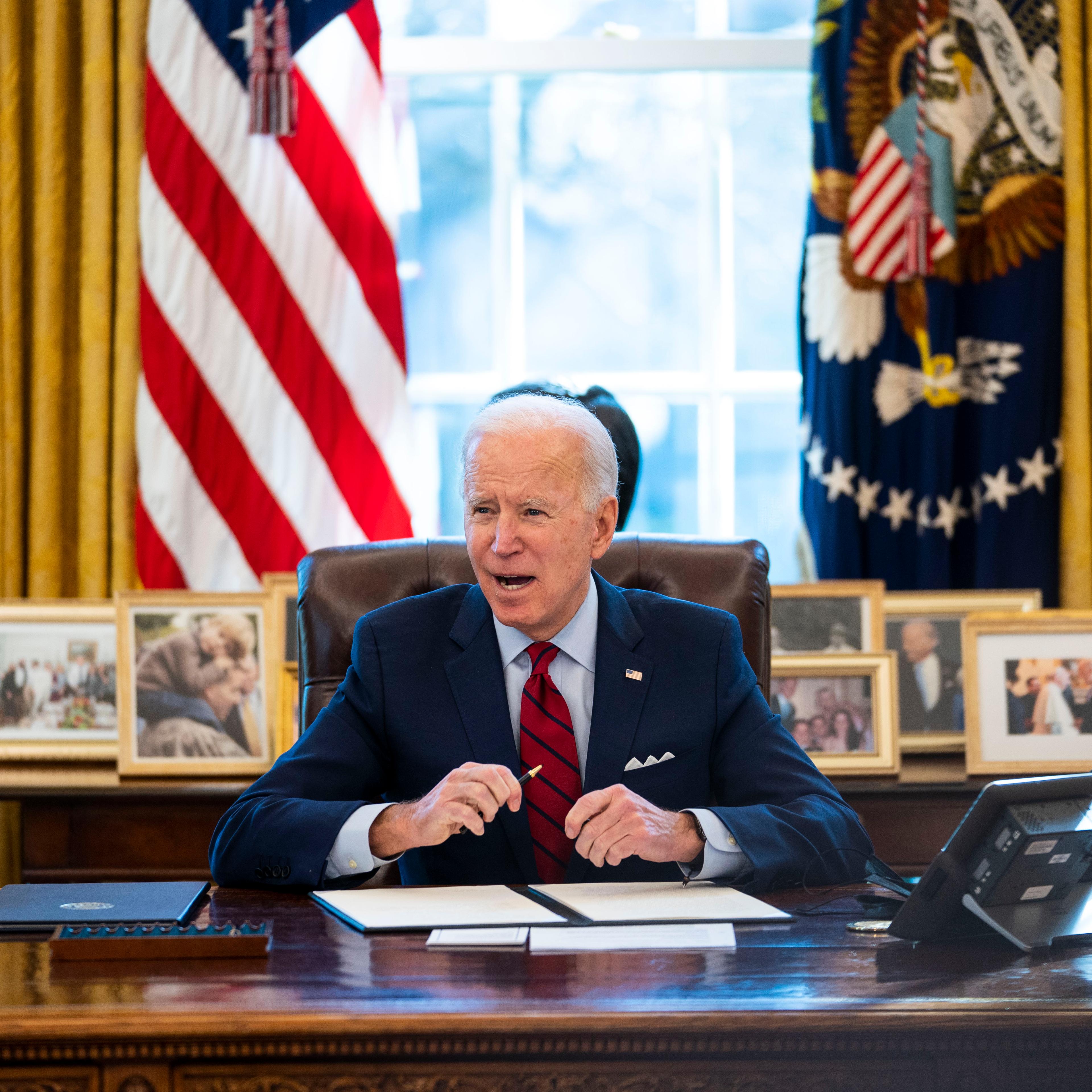 President Joe Biden signs executive actions on health care in the Oval Office of the White House on January 28 in Washington, D.C.