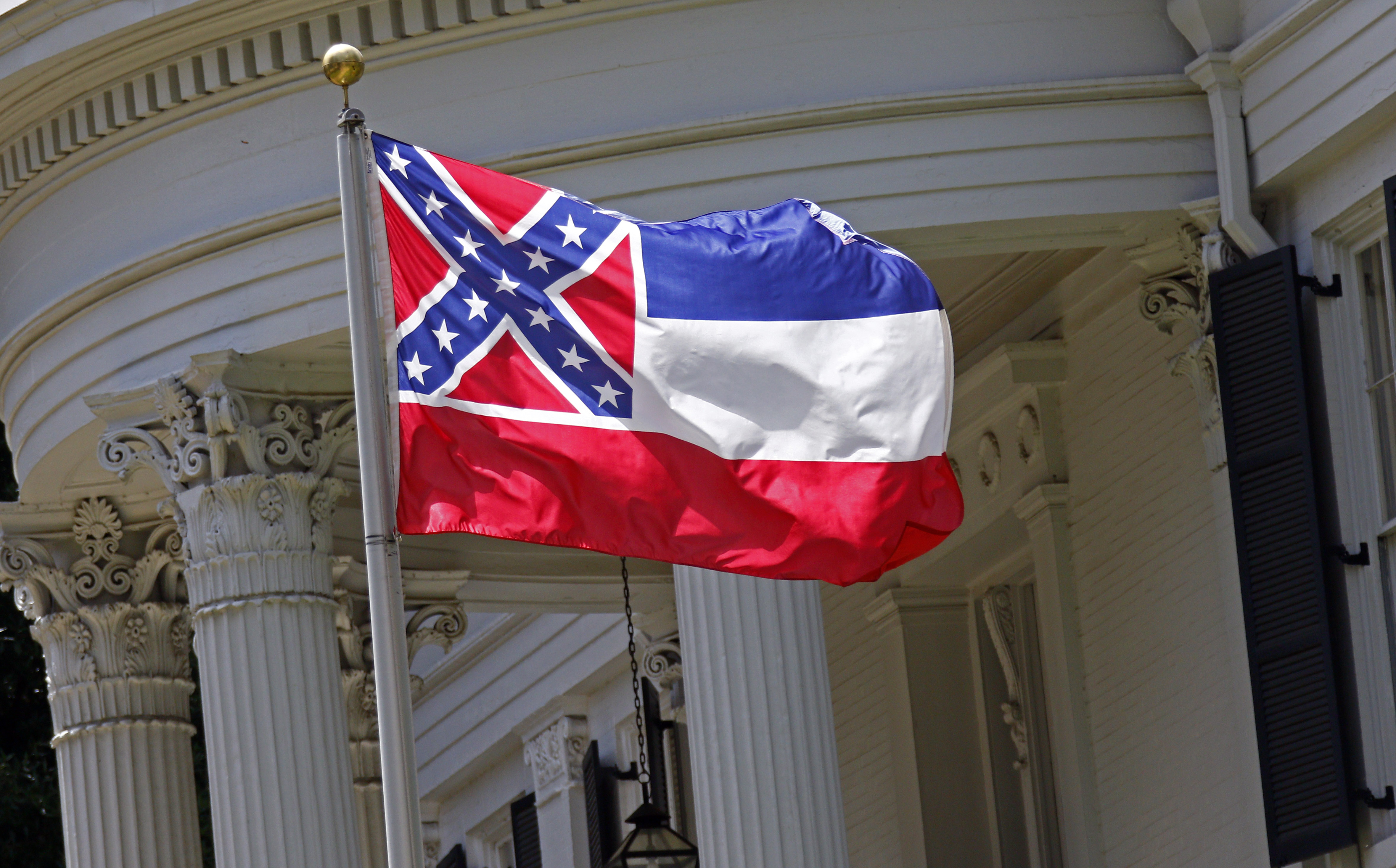 The state flag of Mississippi is unfurled against the front of the Governor's Mansion in Jackson, Miss. on June 23, 2015.