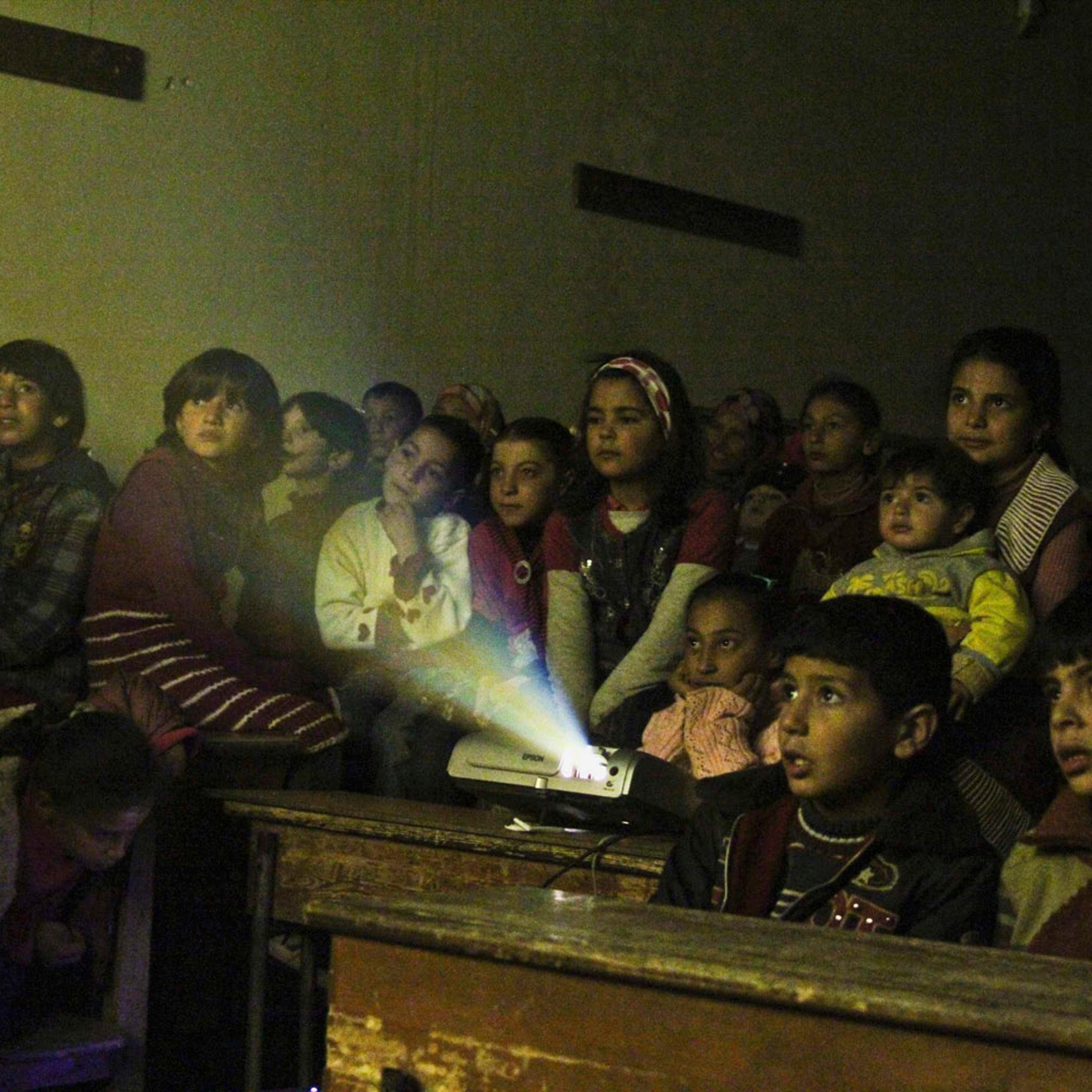 Jan. 16, 2013. Internally displaced children watch cartoons in a classroom of a school in Kafranbel in Idlib province, Syria.