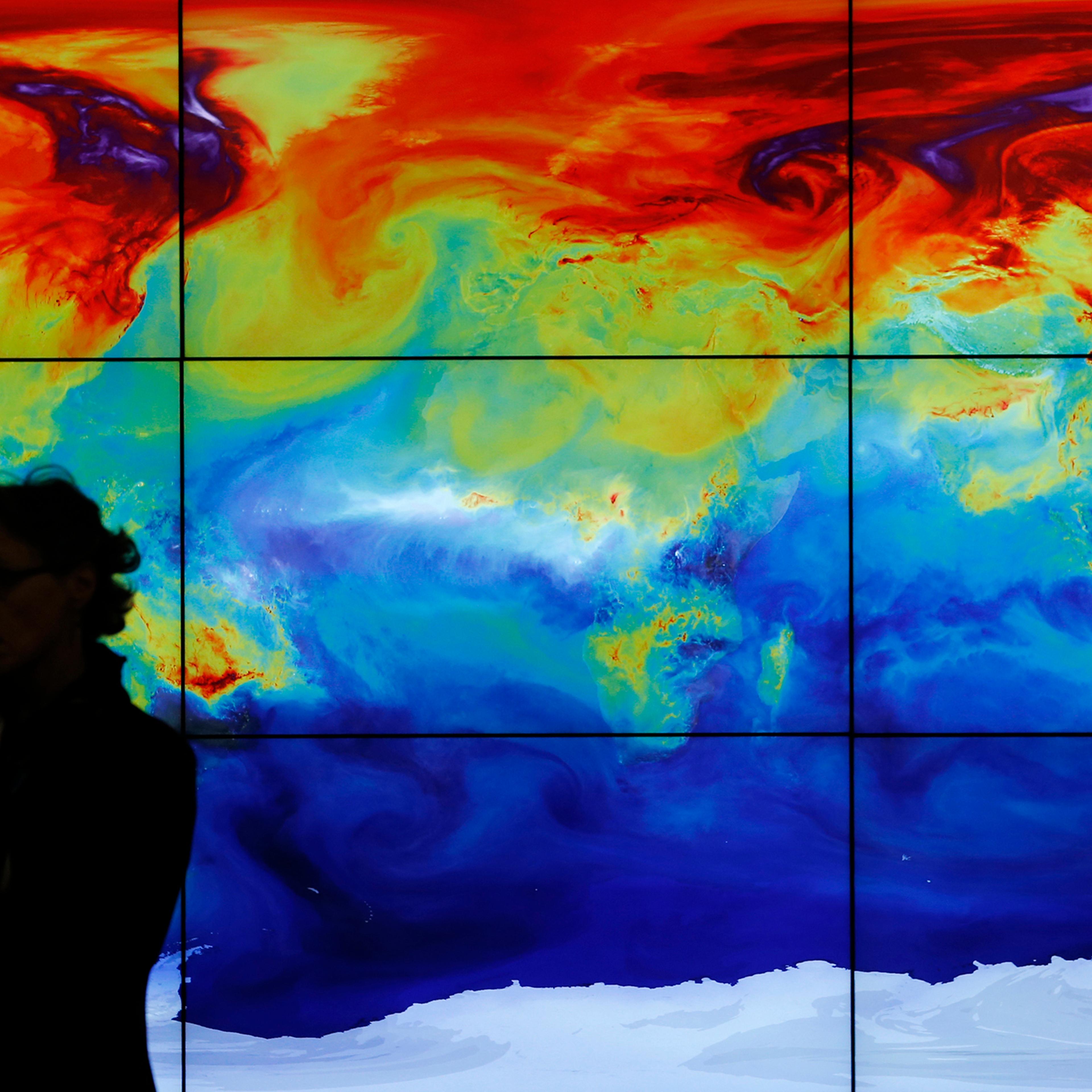 A participant is pictured in front of a screen projecting a world map during the World Climate Change Conference 2015 at Le Bourget, near Paris, Dec. 8, 2015.