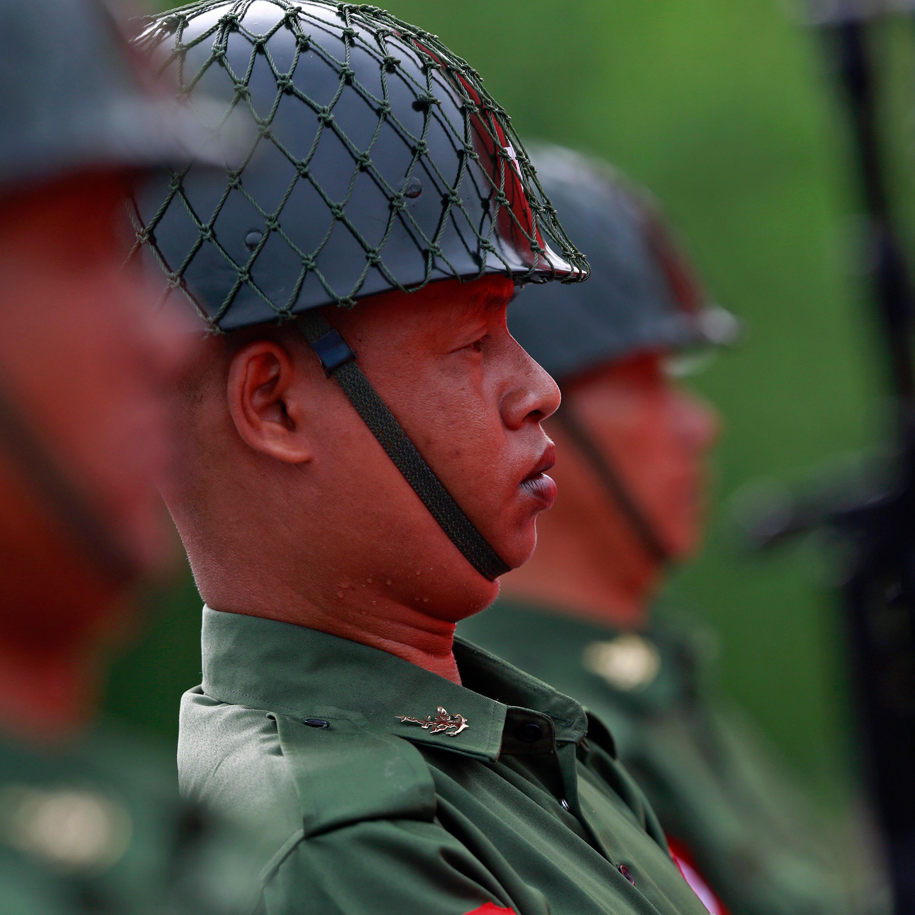Guards of honour salute during an event marking the anniversary of Martyrs' Day at the Martyrs Mausoleum in Yangon