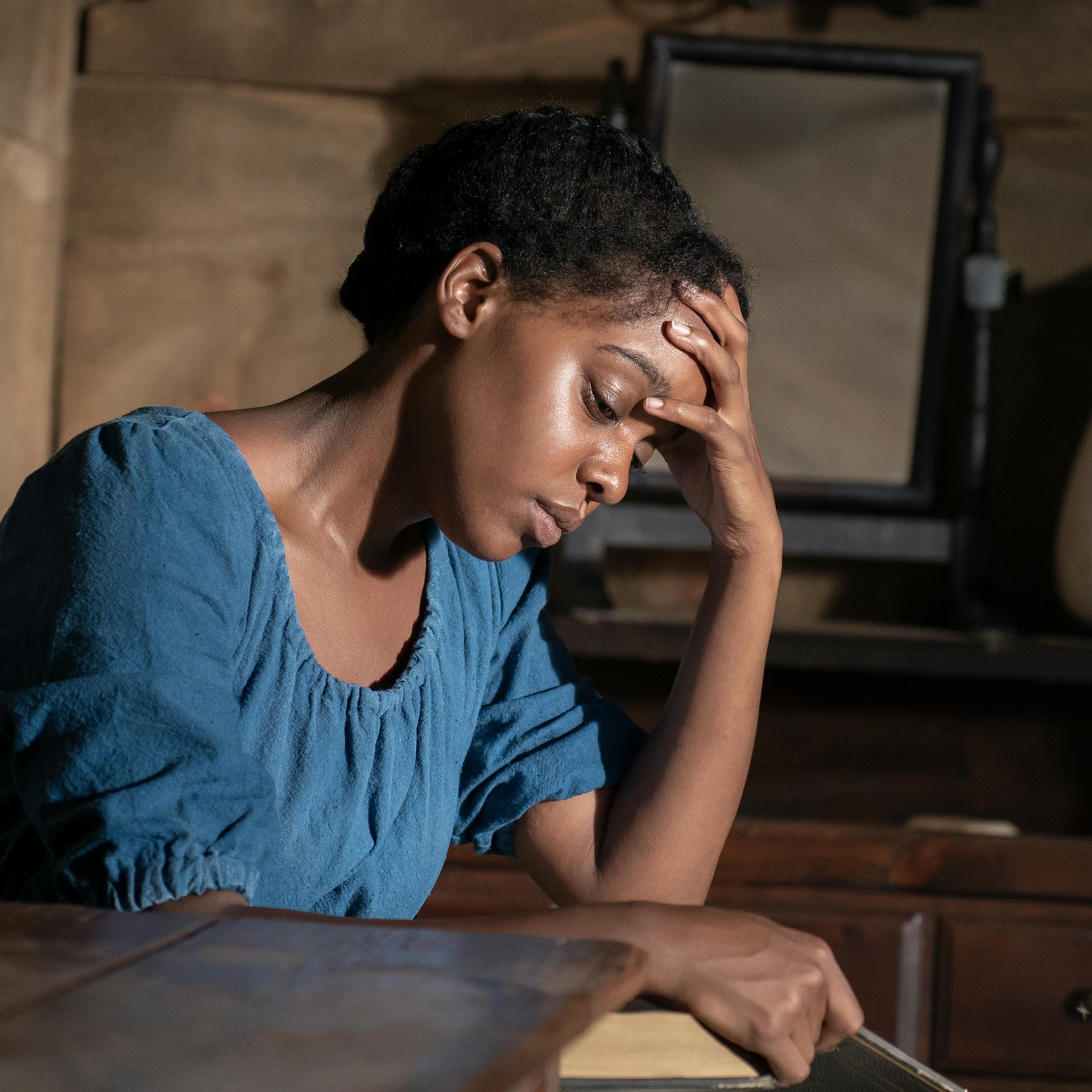 Dana has a hand on her forehead and looks tired or pensive.