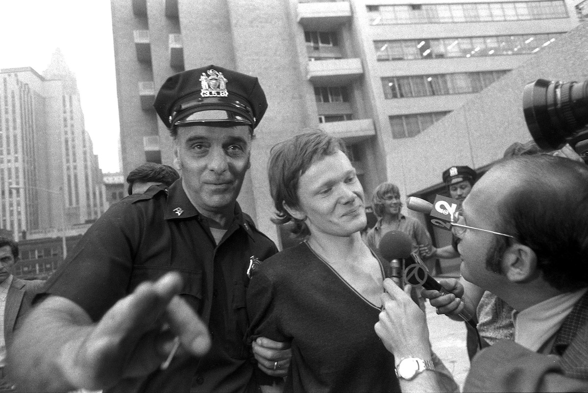 Philippe Petit (center) answers reporter's questions as he i