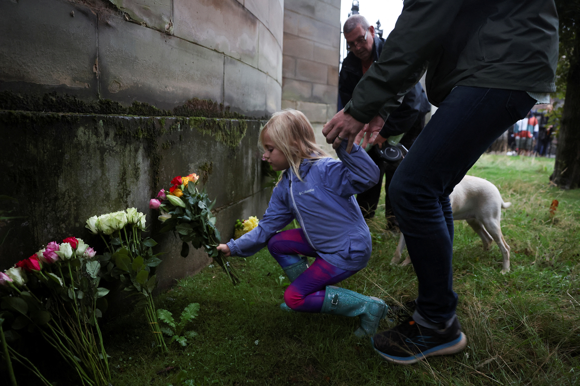 A child places flowers outside the Palace of Holyrood, Edinburgh, Scotland on Sept. 8 after the announcement that Queen Elizabeth, Britain's longest-reigning monarch and the nation's figurehead for seven decades, died aged 96. 