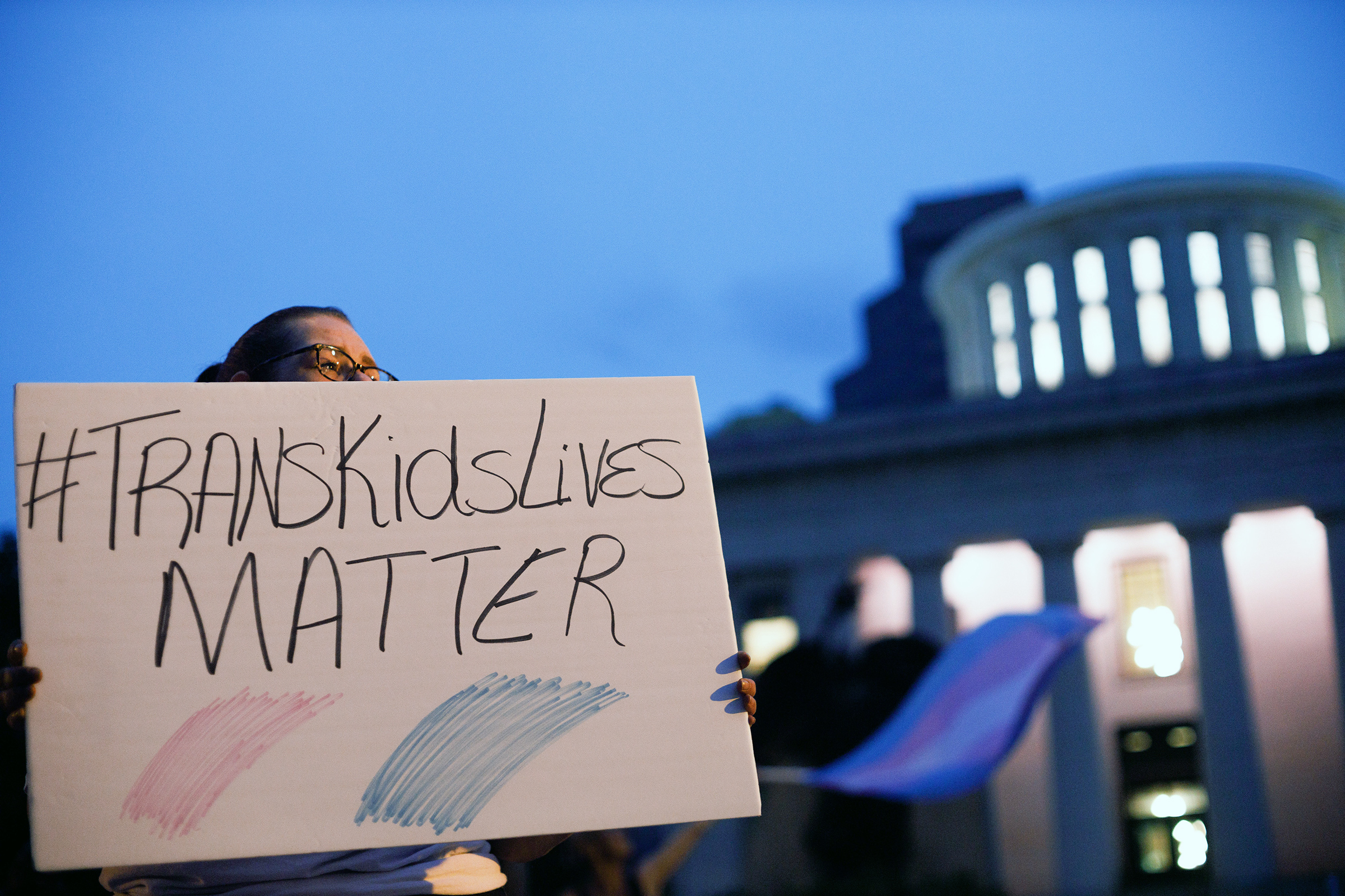 Transgender rights advocate holds a sign outside the Ohio