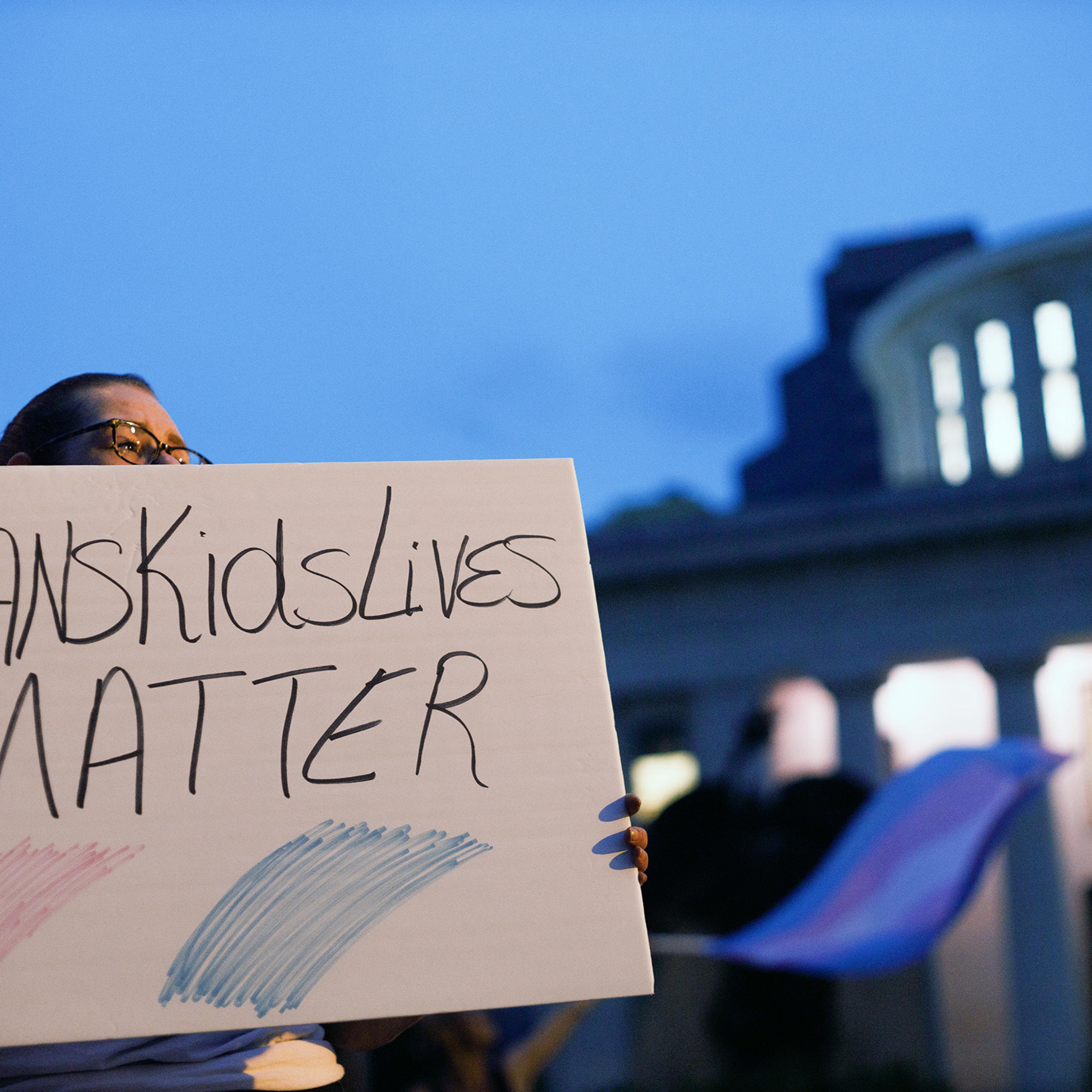 Transgender rights advocate holds a sign outside the Ohio