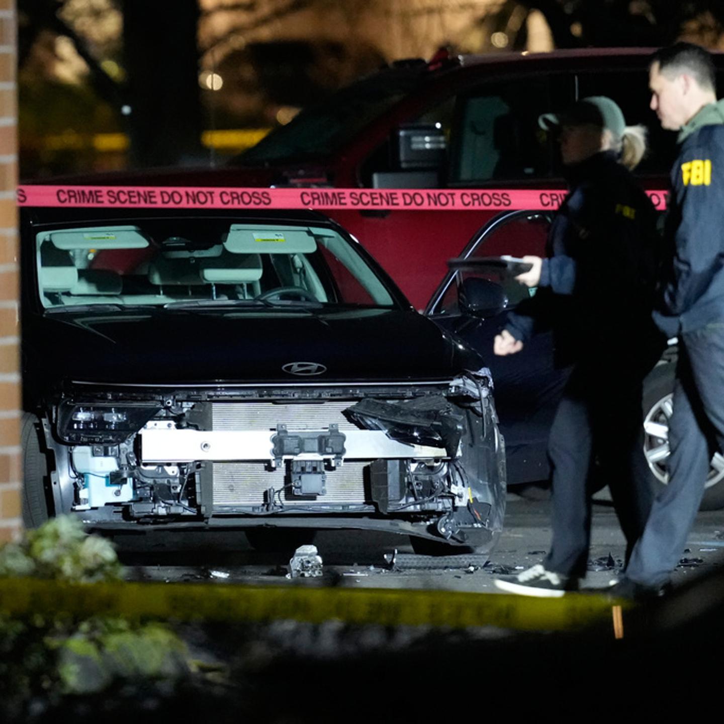 A damaged car is seen as law enforcement officials work the scene following reports that federal immigration officers shot and wounded people in Portland, Ore., Jan. 8, 2026.