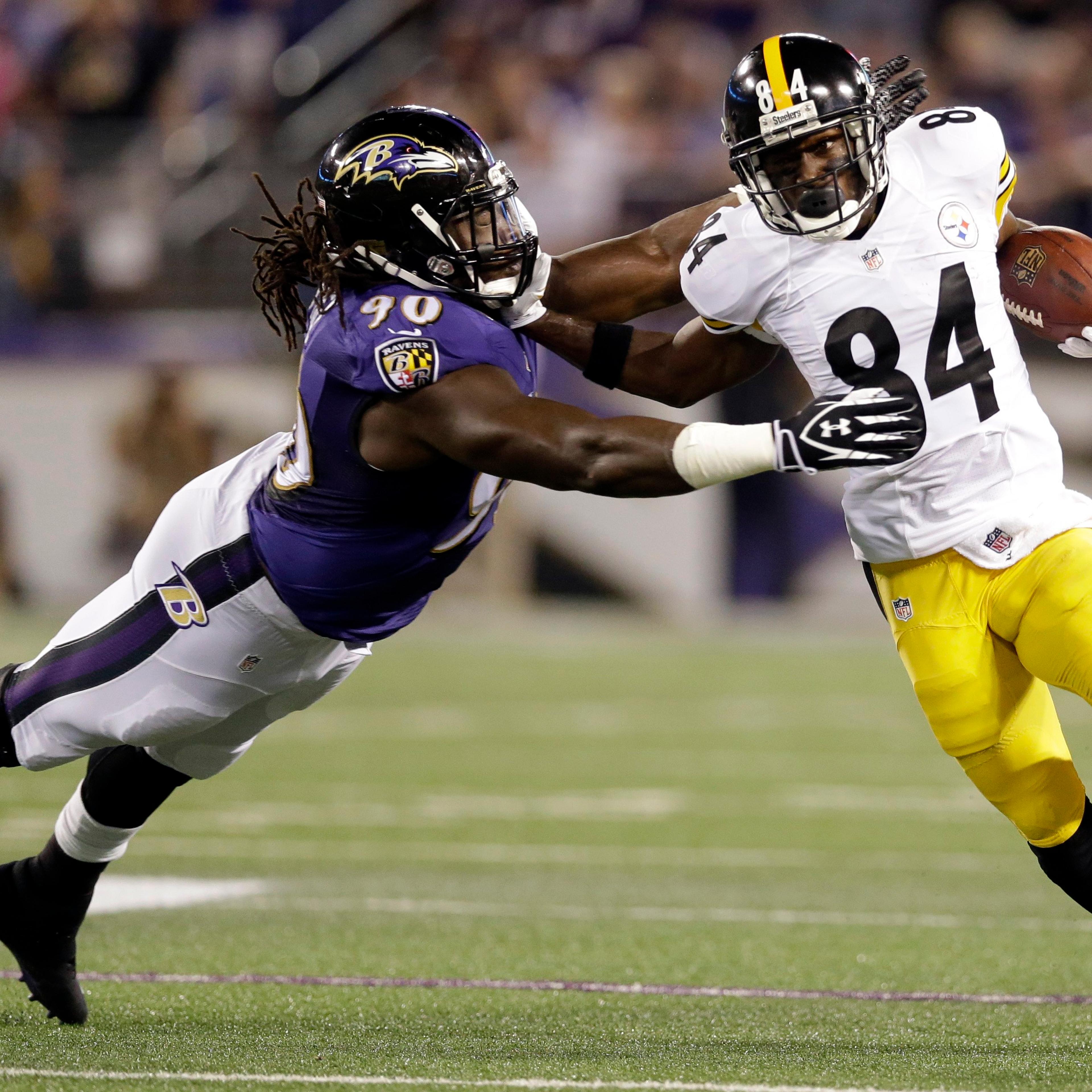 Baltimore Ravens linebacker Pernell McPhee is pushed away by Pittsburgh Steelers wide receiver Antonio Brown during the first half of an NFL football game on Sept. 11, 2014, in Baltimore.