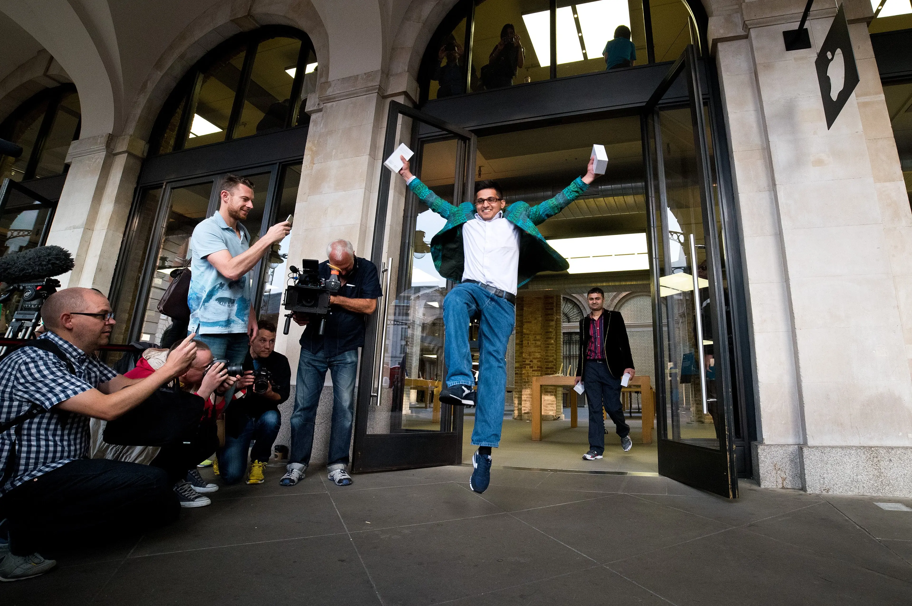 Jamael Ahmed jumps in the air as he leaves the store after being the first to purchase the iPhone 6 at Apple Covent Gardens in London on Sept. 19, 2014.