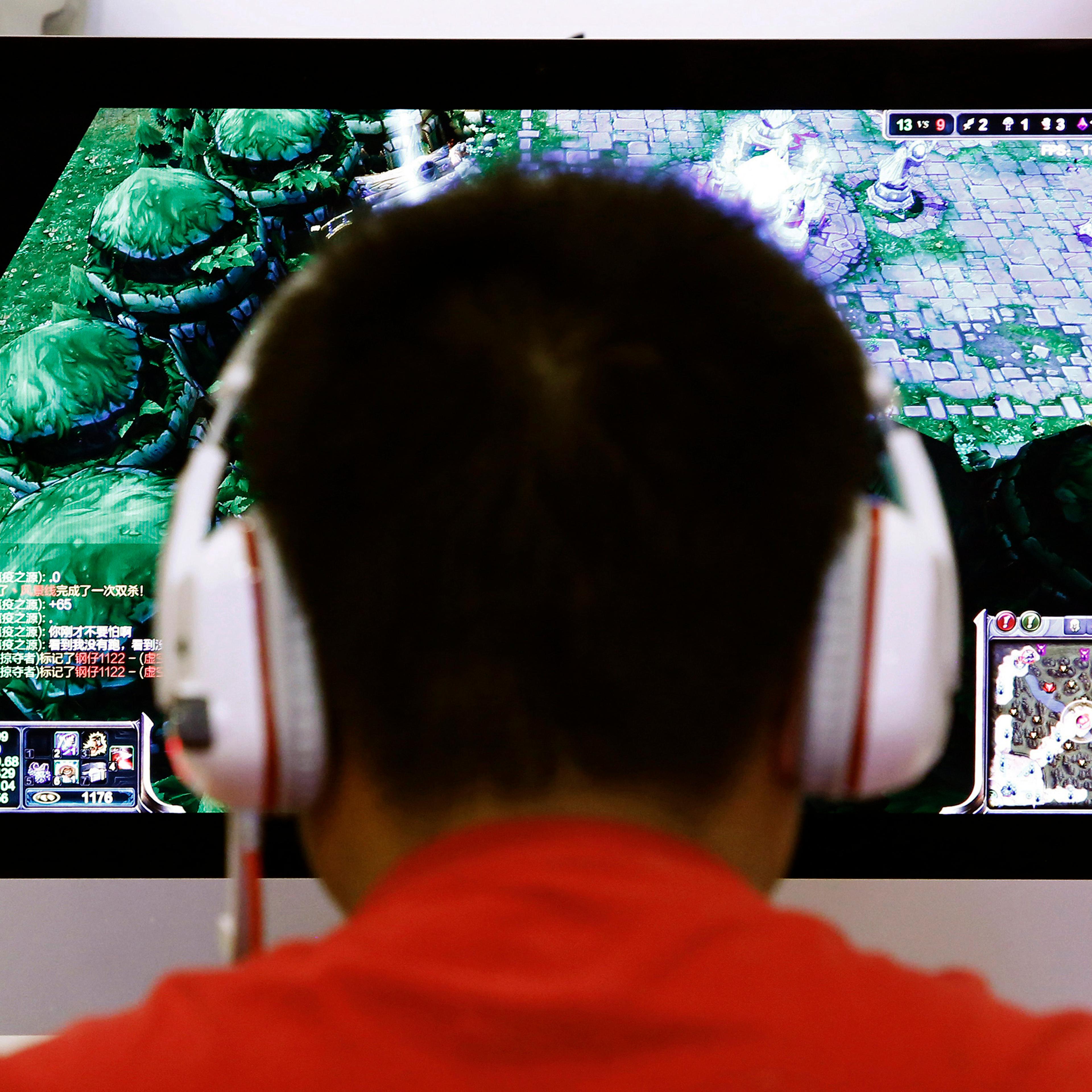 A man plays a computer game at an internet cafe in Beijing