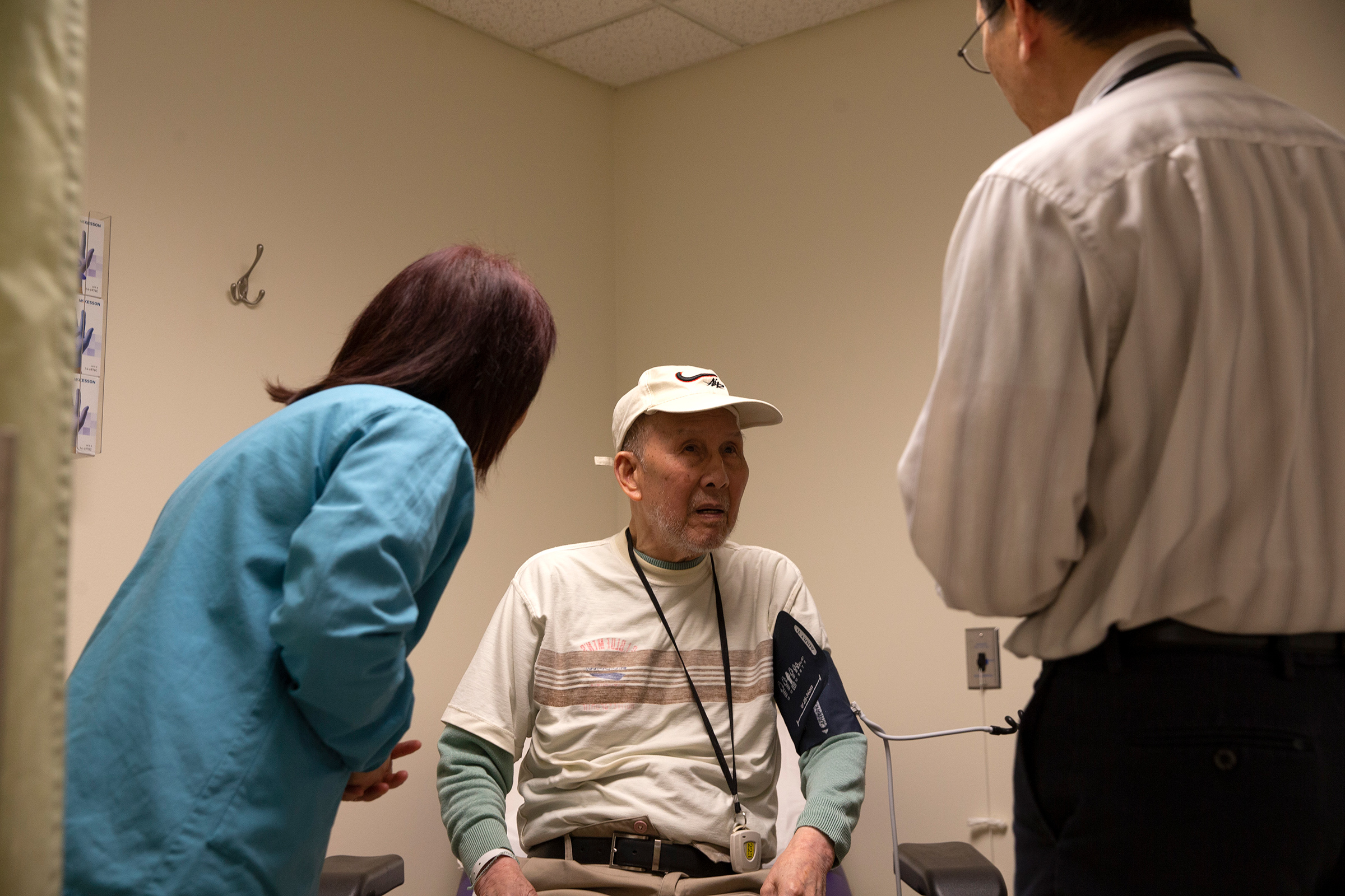 Bing Hong Liu (C) talks to to Dr. Alan Chun (R) through an interpreter at the International Community Health Services medical clinic in their assisted living facility, the Legacy House, on March 20 in Seattle.