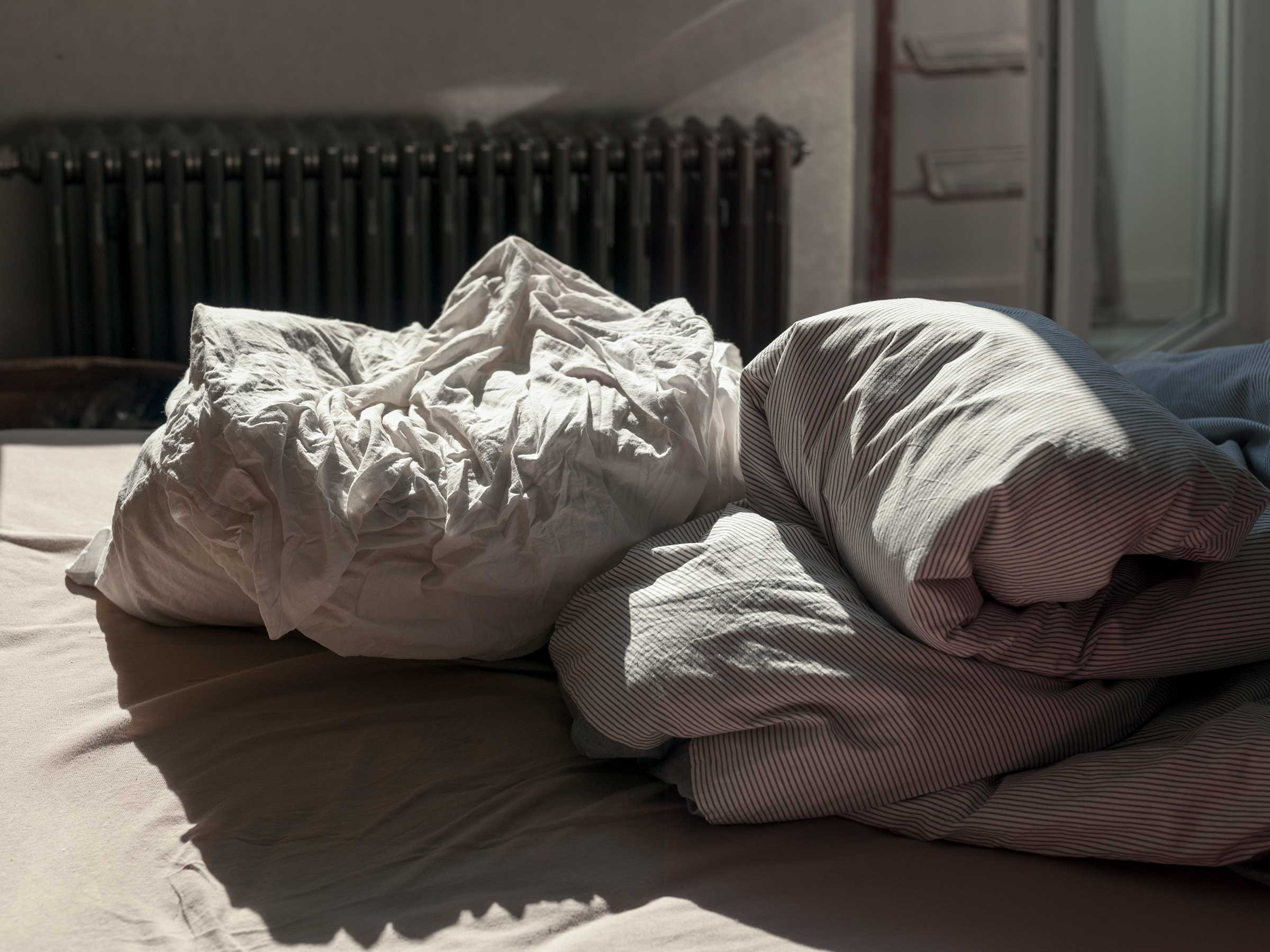 Sheets and blankets on an unmade bed