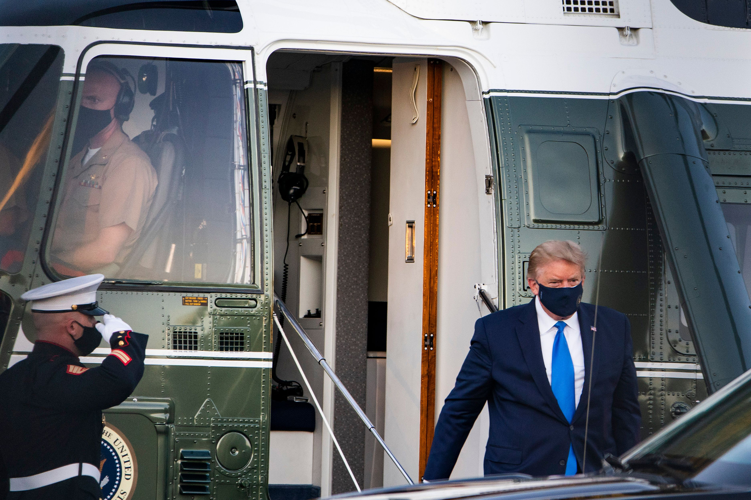 President Trump walks off Marine One after landing at Walter Reed National Military Medical Center in Bethesda, Md., on Oct. 2, 2020. His positive COVID-19 test comes after months of playing down the severity of the pandemic that has killed 207,000 Ameri
