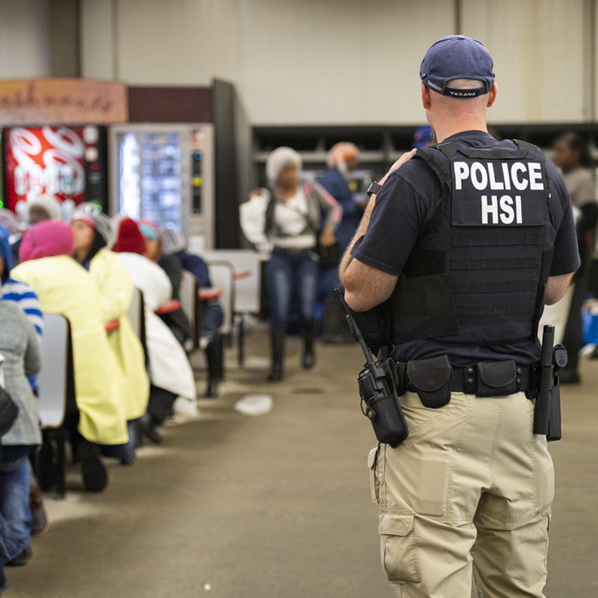 Homeland Security Investigations officers from Immigration and Customs Enforcement (ICE) look on after executing search warrants and making arrests at an agricultural processing facility in Canton, Mississippi