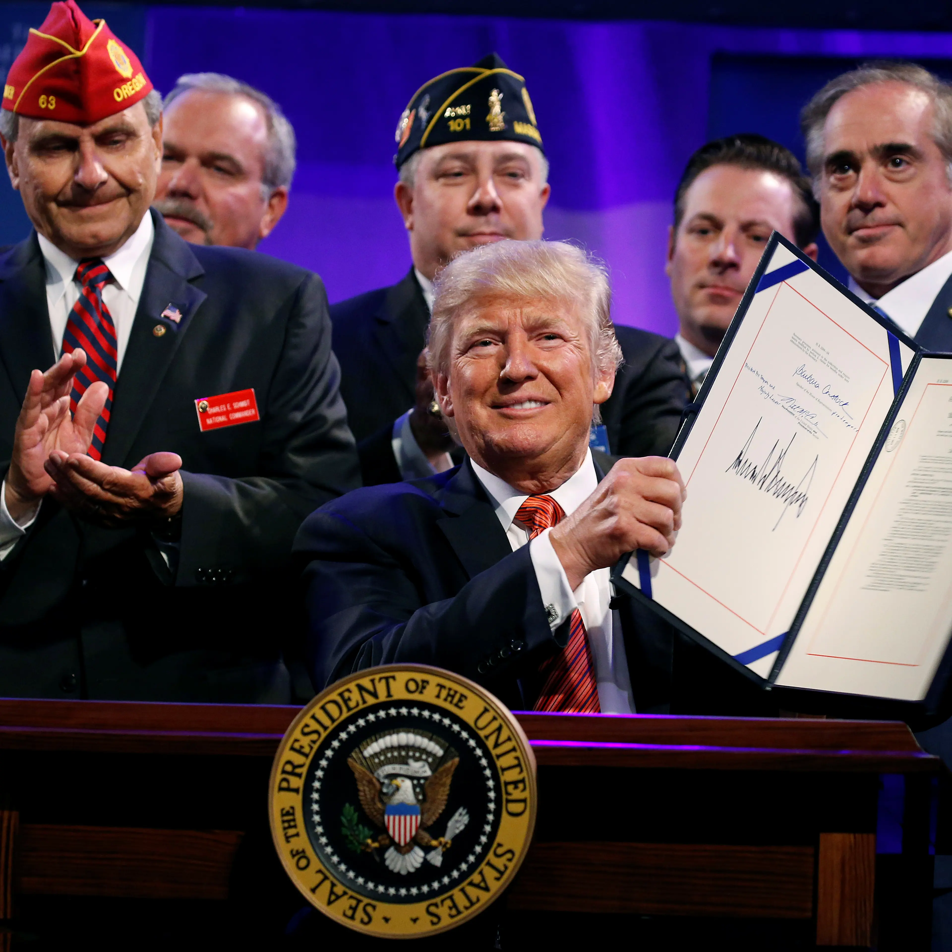 U.S. President Donald Trump holds up the Veterans Appeals Improvement and Modernization Act after signing it in Reno, Nevada