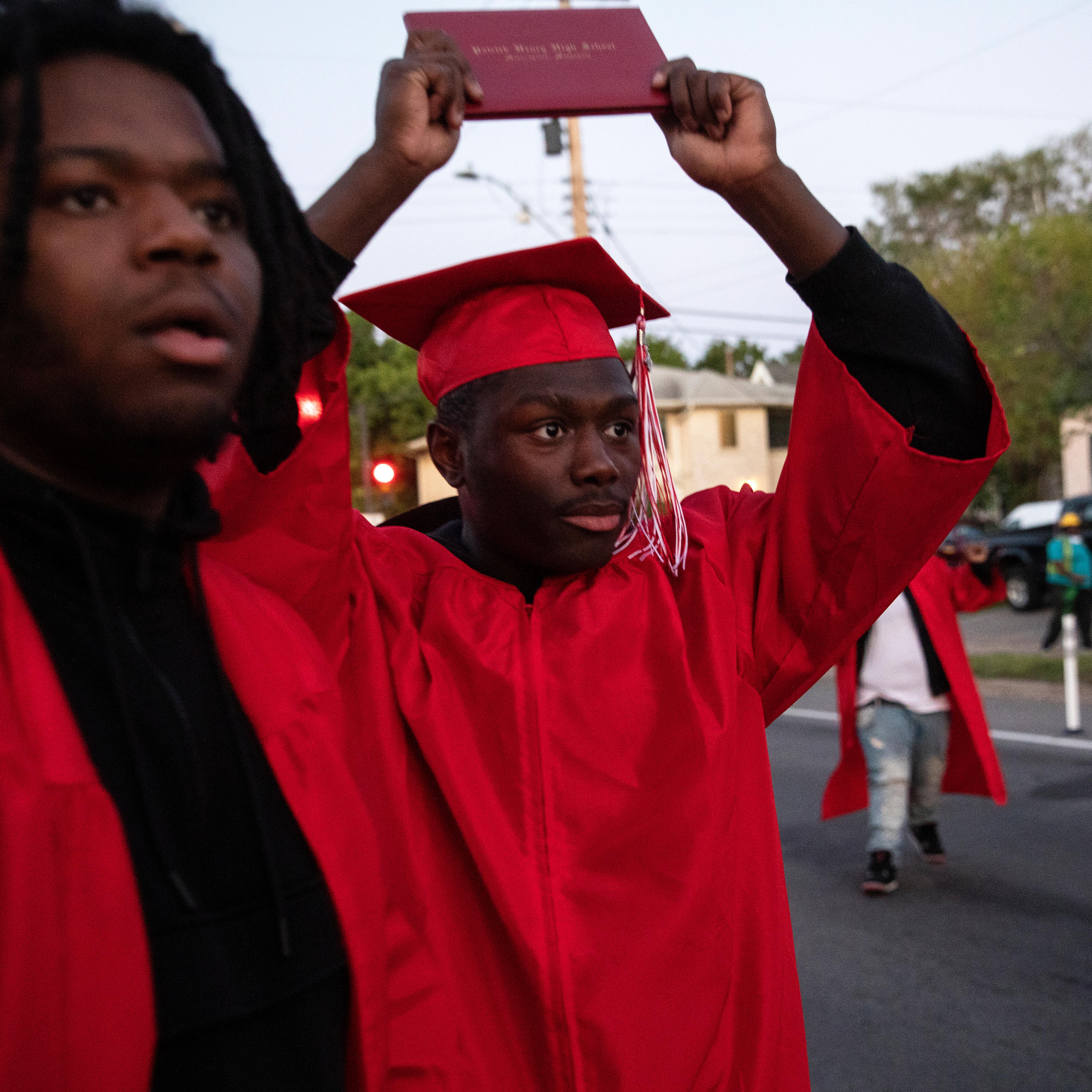 I saw Datelle Straub, Avery Lewis, and Titan Harness-Reed pull up to the street protests wearing their bright red 2020 graduation caps and gowns from Patrick Henry High School. Datelle saw the police advancing on the group and raised his diploma in the a