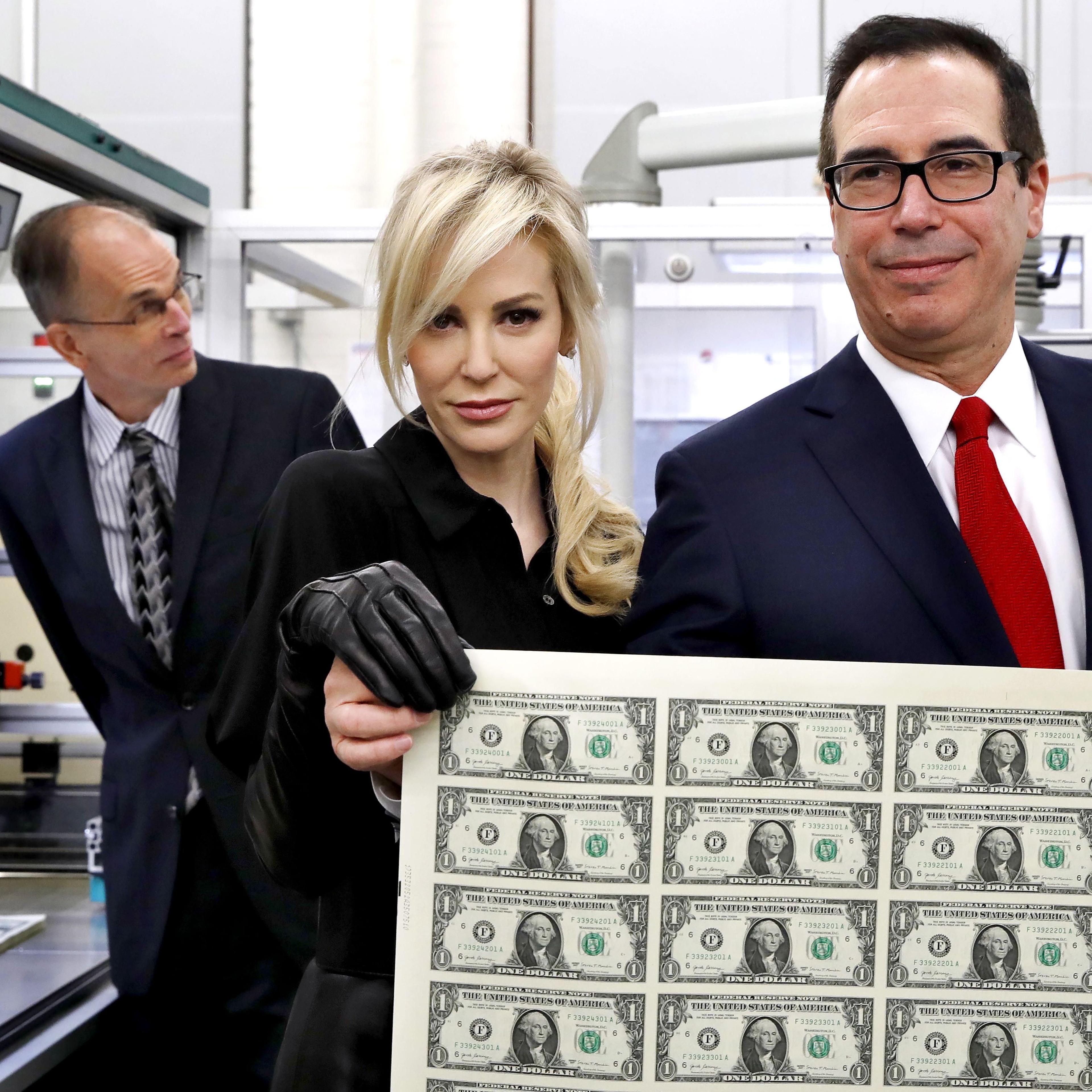 Treasury Secretary Steven Mnuchin, right, and his wife Louise Linton, hold up a sheet of new $1 bills, the first currency notes bearing his and U.S. Treasurer Jovita Carranza's signatures, in Washington on Nov. 15.
