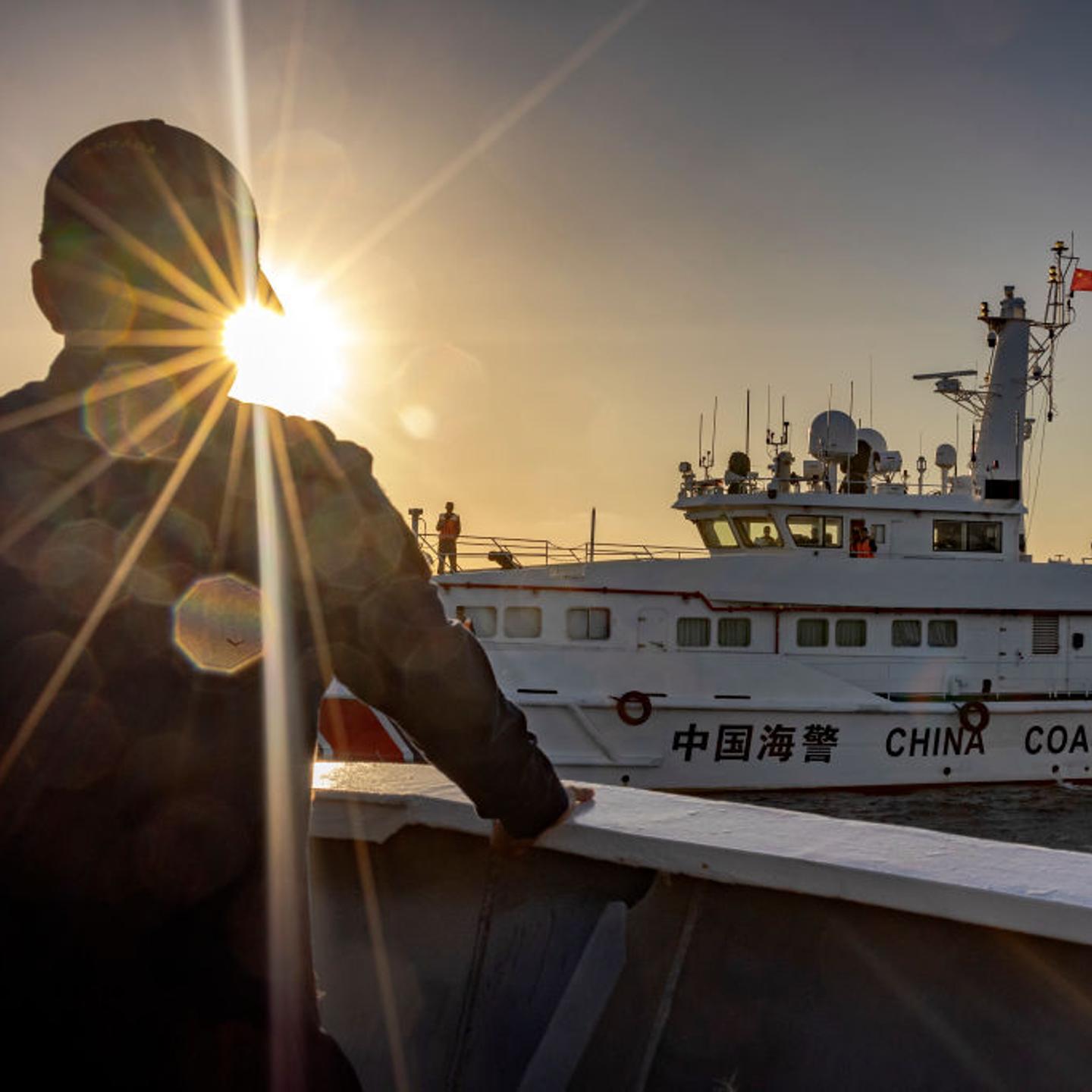 A Philippine Coast Guard personnel aboard BRP Sindangan looks on as a Chinese Coast Guard ship sails nearby, during resupply mission to troops stationed at Second Thomas Shoal, on March 5, 2024 in the South China Sea.