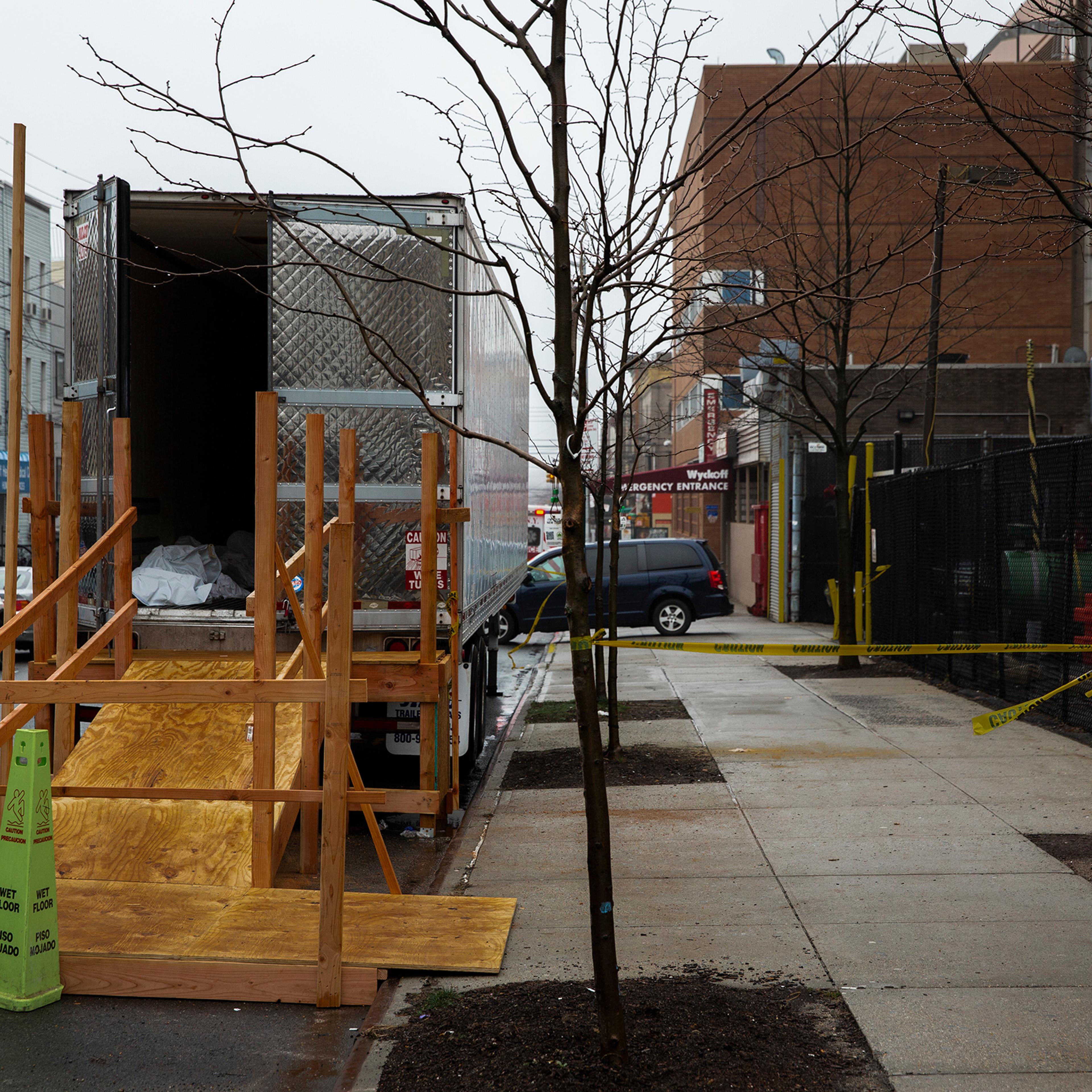 A covered body is seen in the back of a morgue truck parked outside Wyckoff Heights Medical Center in Brooklyn, New York, on March 29, 2020.