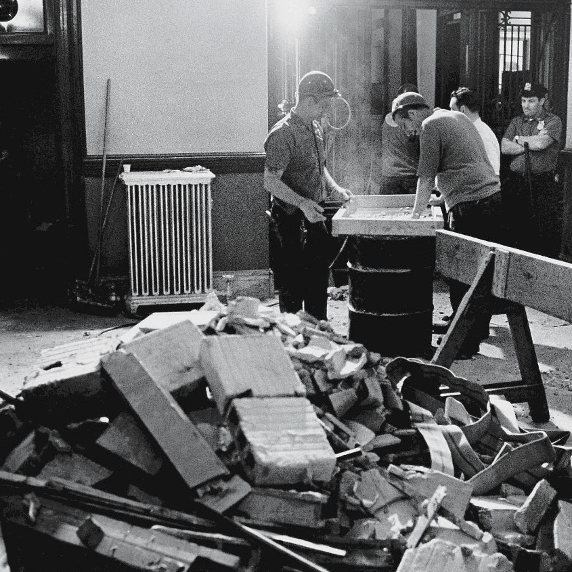 Construction workers and policemen stand around a pile of rubble in the police headquarters building after a bombing by the Weathermen Underground Organization, an offshoot of the SDS, New York, June 9, 1970.