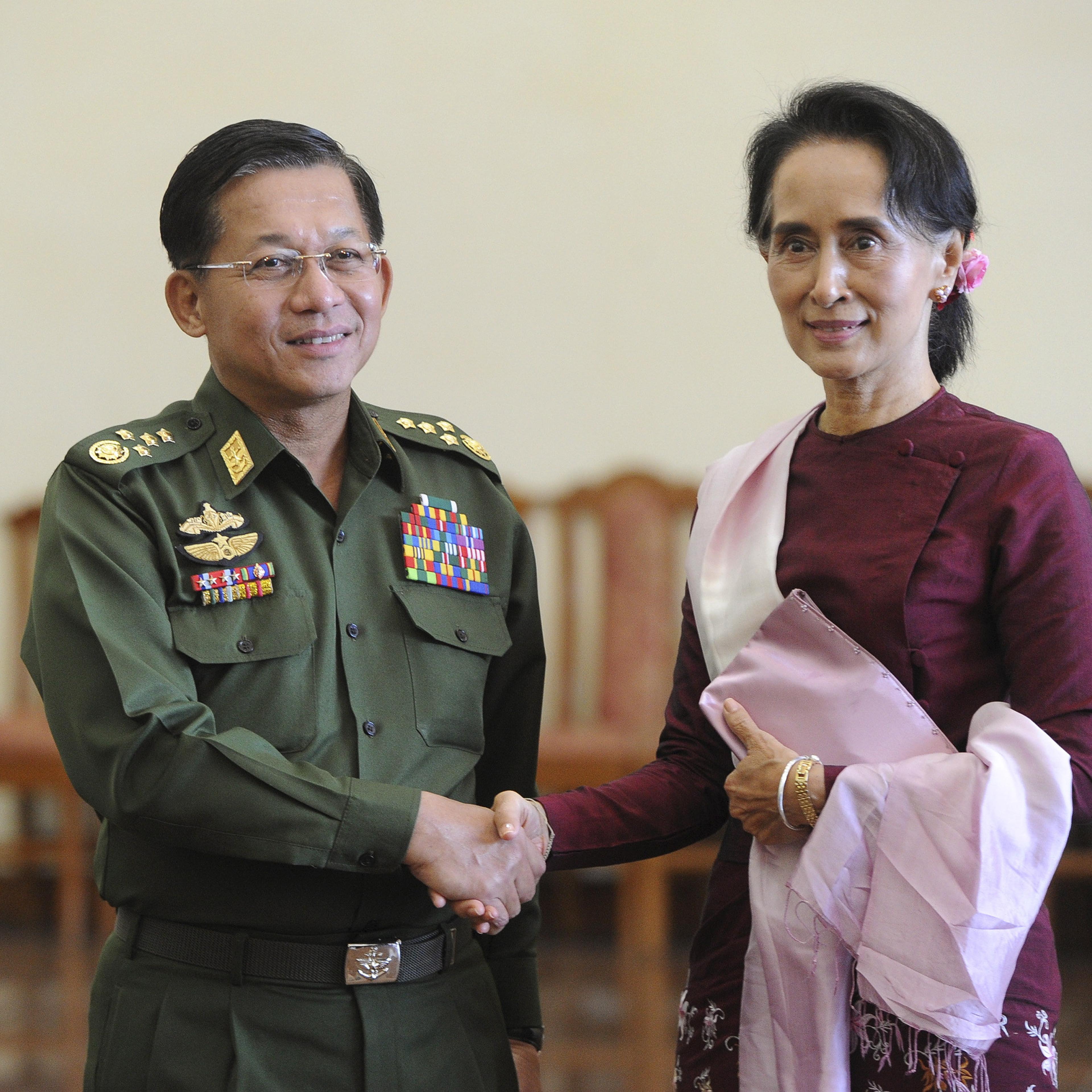 Myanmar's Commander-in-Chief Min Aung Hlaing and National League for Democracy (NLD) party leader Aung San Suu Kyi shake hands after their meeting in Naypyitaw