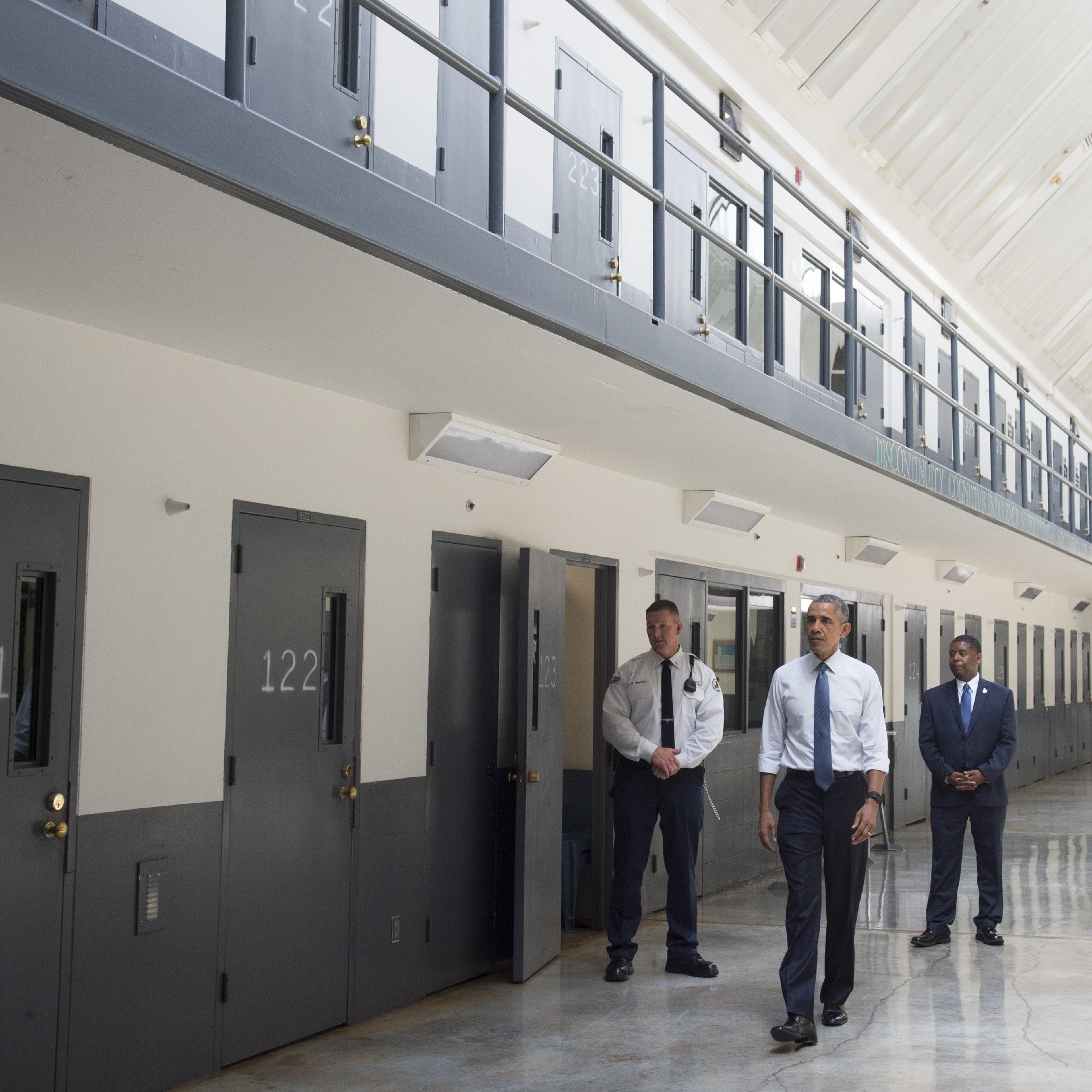 Barack Obama, alongside Charles Samuels (R), Bureau of Prisons Director, and Ronald Warlick (L), a correctional officer, tours a cell block at the El Reno Federal Correctional Institution in El Reno, Oklahoma, July 16, 2015.