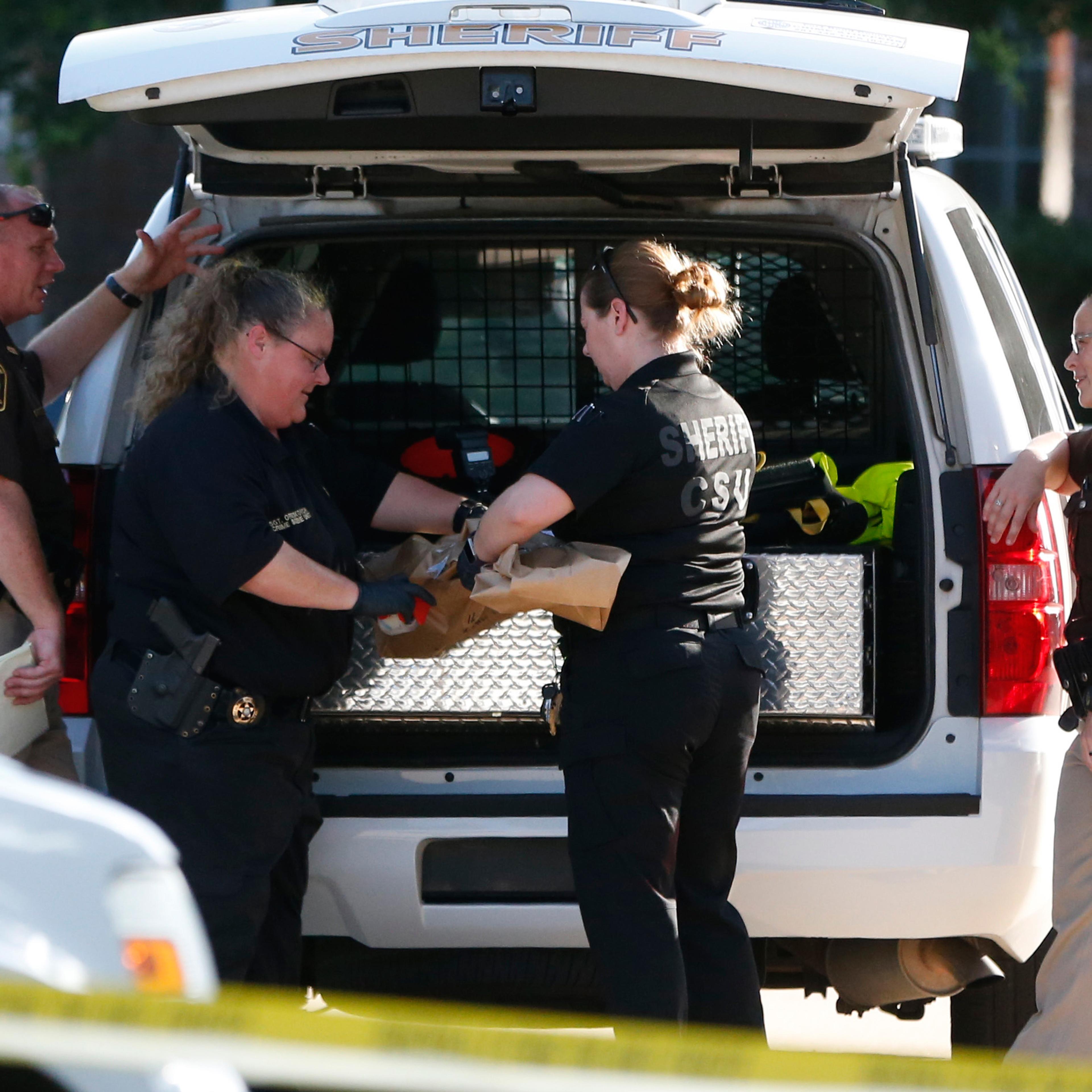 Fort Bend County Sheriffs department crime scene members bag a gun for evidence in a shooting at Blanchard Grove and Remson Hollow in Katy, Texas on June 24, 2016.
