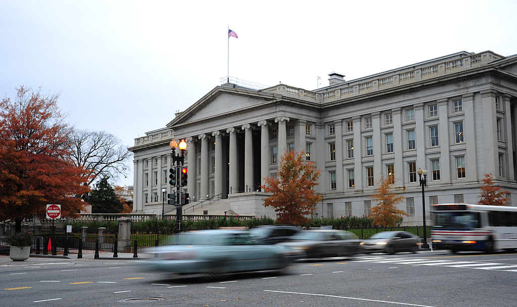 Vehicles drive by the U.S. Treasury Building
