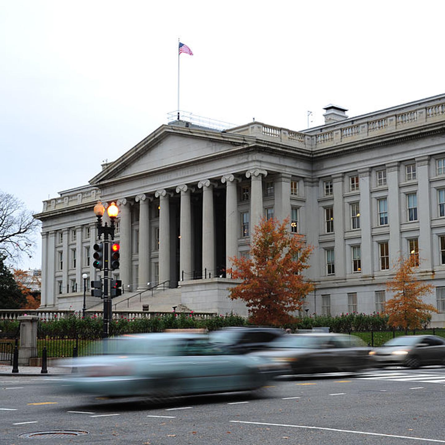 Vehicles drive by the U.S. Treasury Building