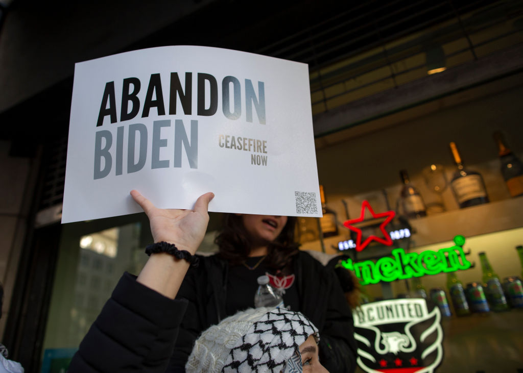 A demonstrator holding a sign with the text reading "