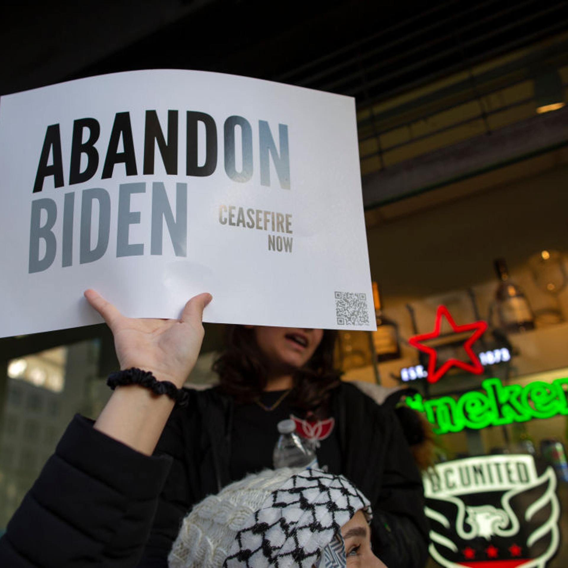 A demonstrator holding a sign with the text reading "