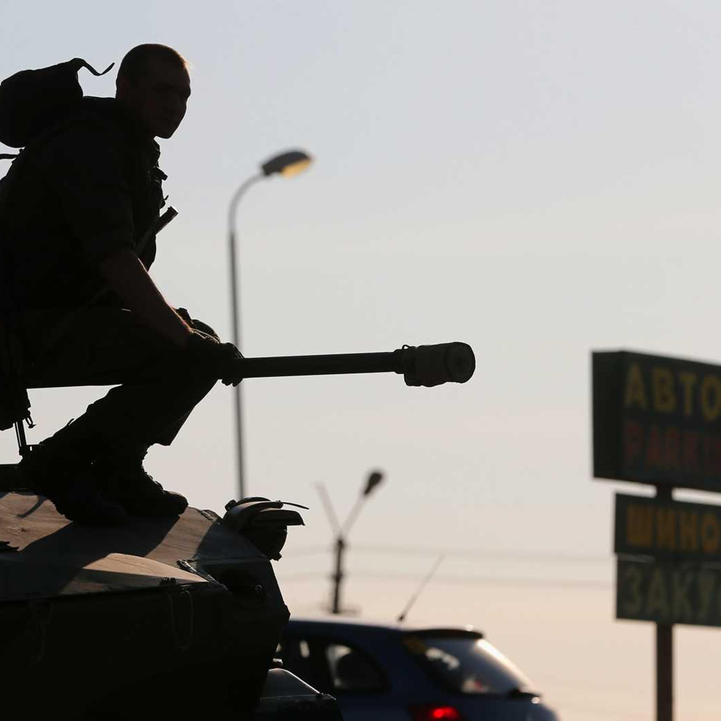 A Russian serviceman sits atop an armored vehicle outside Kamensk-Shakhtinsky, Russia's Rostov region, on Aug. 15, 2014. Dozens of heavy Russian military vehicles amassed on Friday near the border with Ukraine where a huge Russian convoy with humanitarian aid came to a halt as Moscow and Kiev struggled to agree border crossing procedures