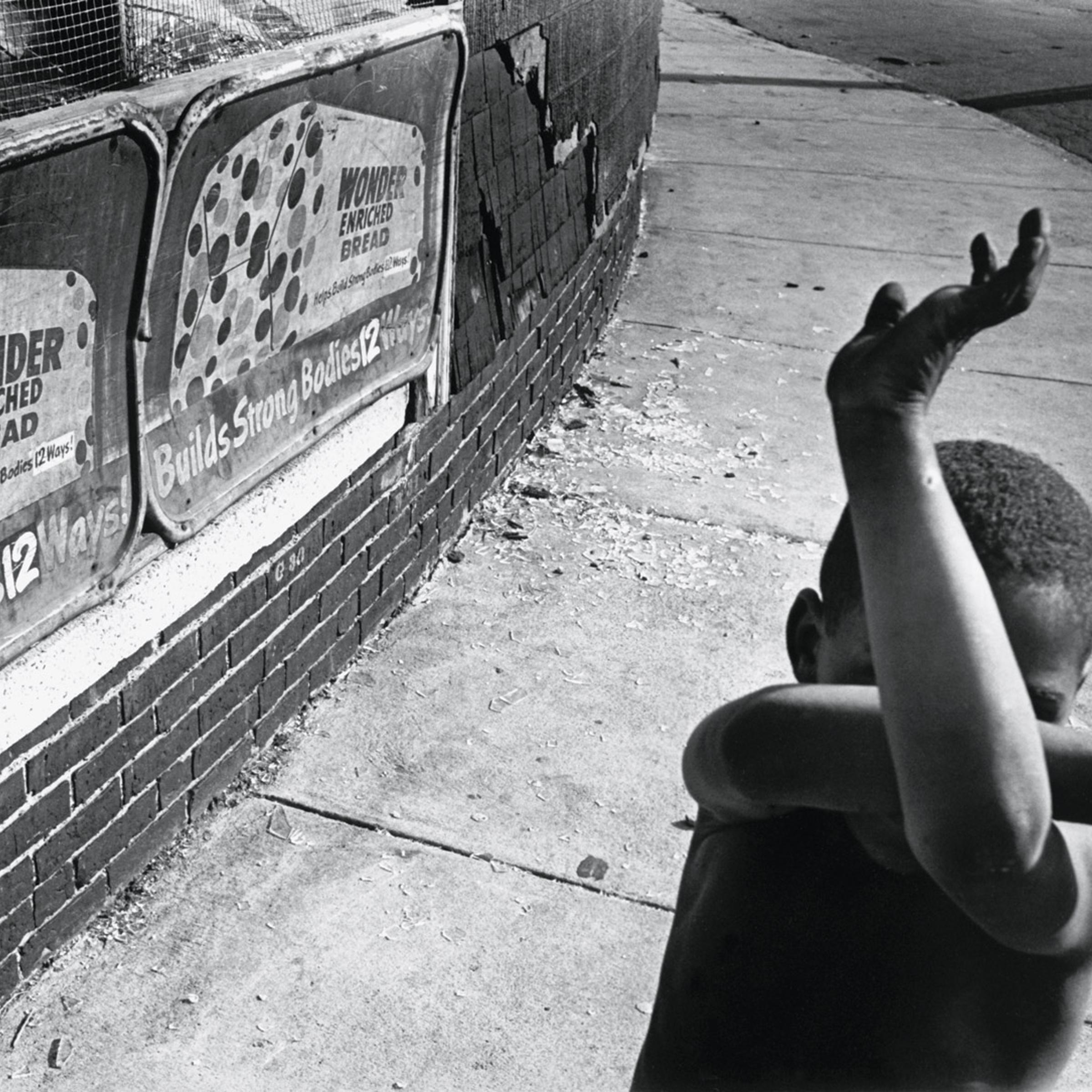 <b><i>Wonder Bread, Dorchester, Massachusetts</i>, by Eugene Richards, 1975/1997.</b><br>
"A great street picture that has some political overtones. It speaks of youth and the potential of life—I love the way his arms are criss-crossed in this funny little matrix. This is a picture full of wonder, and at the same time, dread of what the future is."