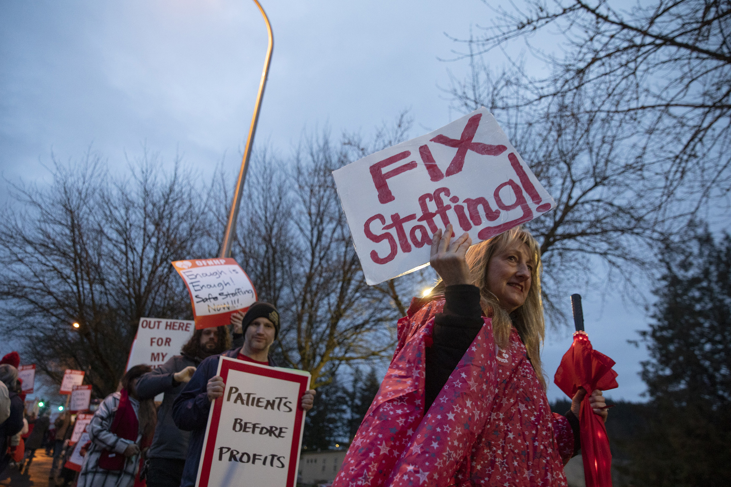 Kaiser Permanente nurses and healthcare professionals hold placards on a picket line outside of Sunnyside Medical Center in Clackamas, Ore., on Jan. 13. The health care workers were picketing over what they said were critically low staffing levels.