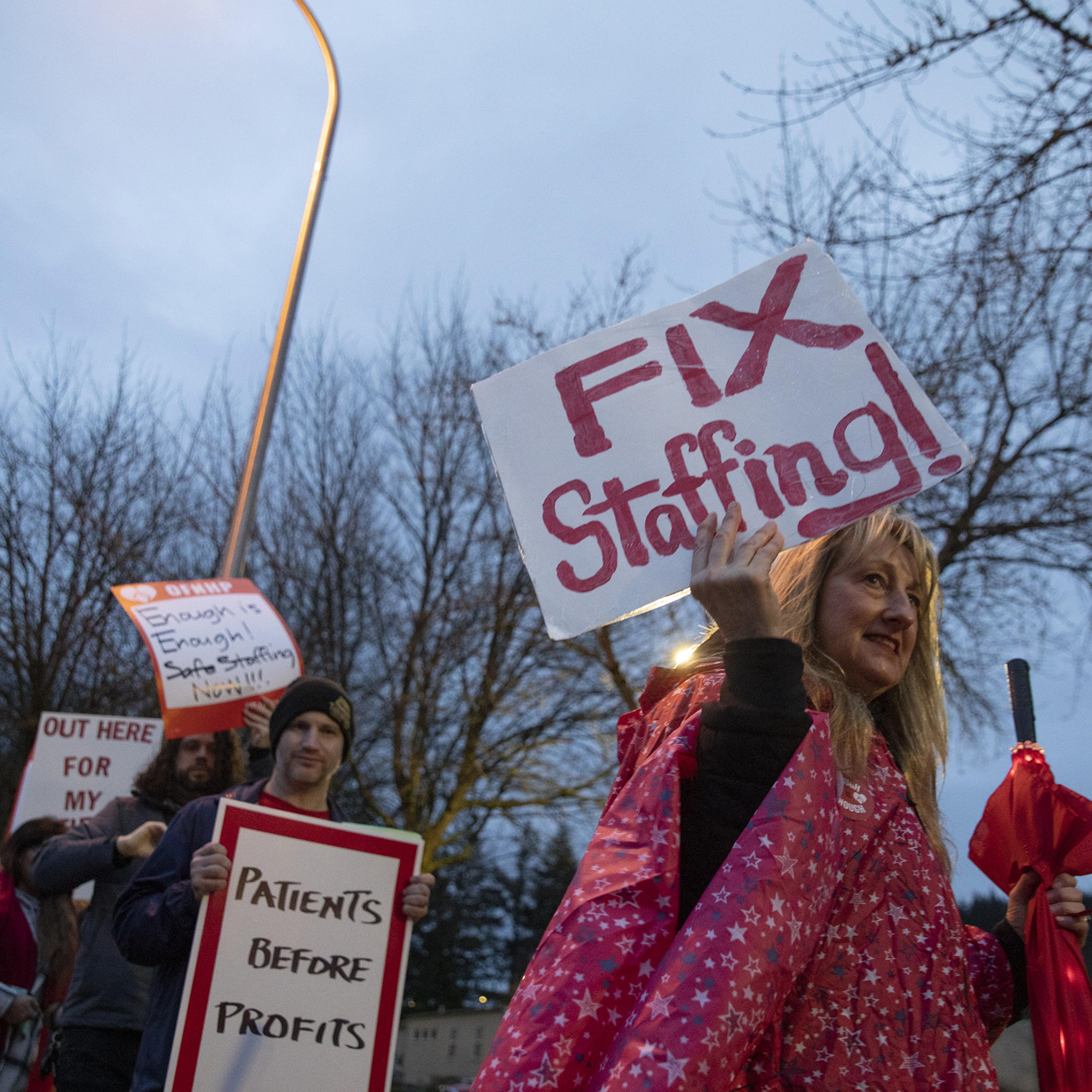 Kaiser Permanente nurses and healthcare professionals hold placards on a picket line outside of Sunnyside Medical Center in Clackamas, Ore., on Jan. 13. The health care workers were picketing over what they said were critically low staffing levels.