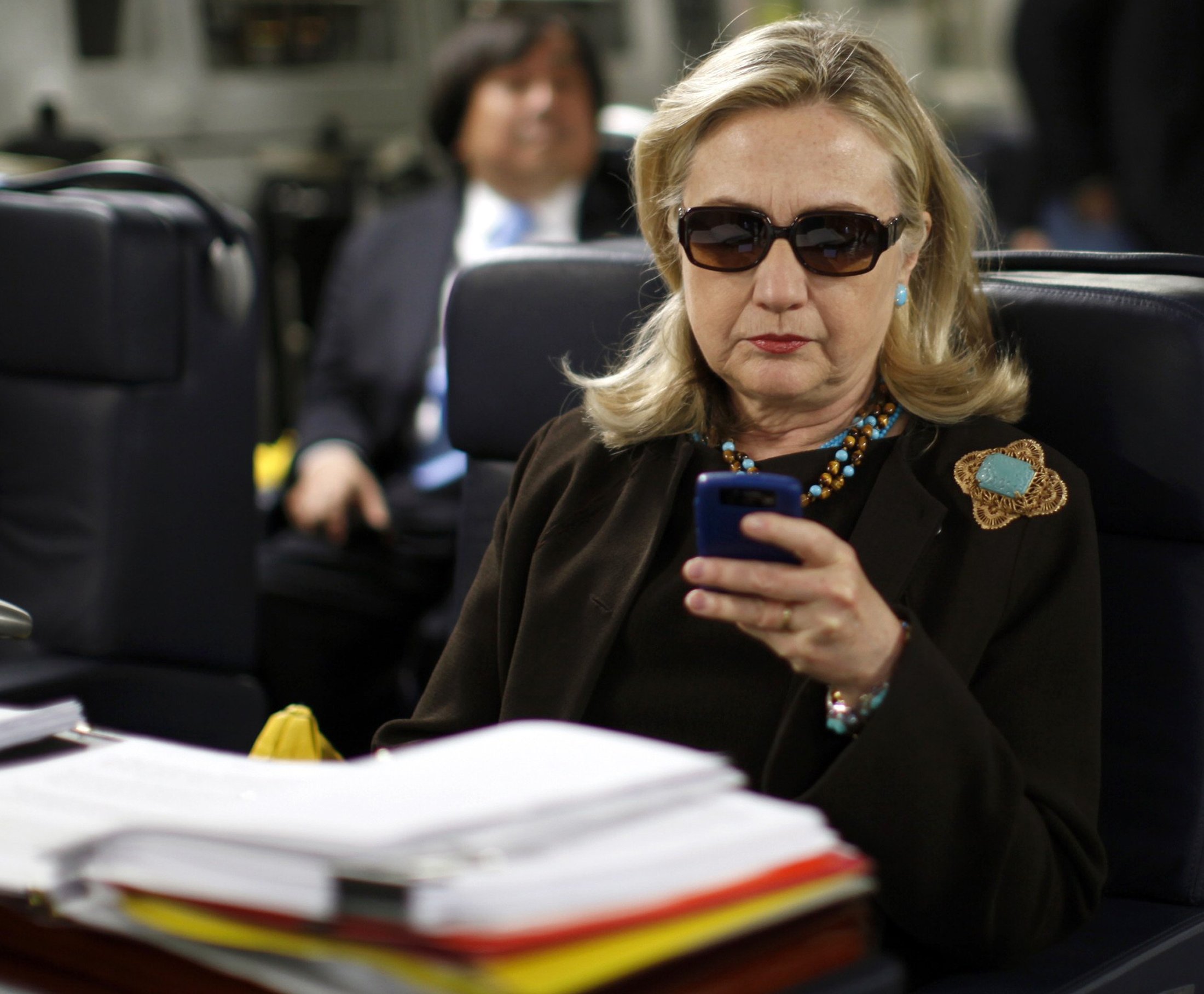 Former Secretary of State Hillary Clinton checks her PDA upon her departure in a military C-17 plane from Malta bound for Tripoli on Oct. 18, 2011.