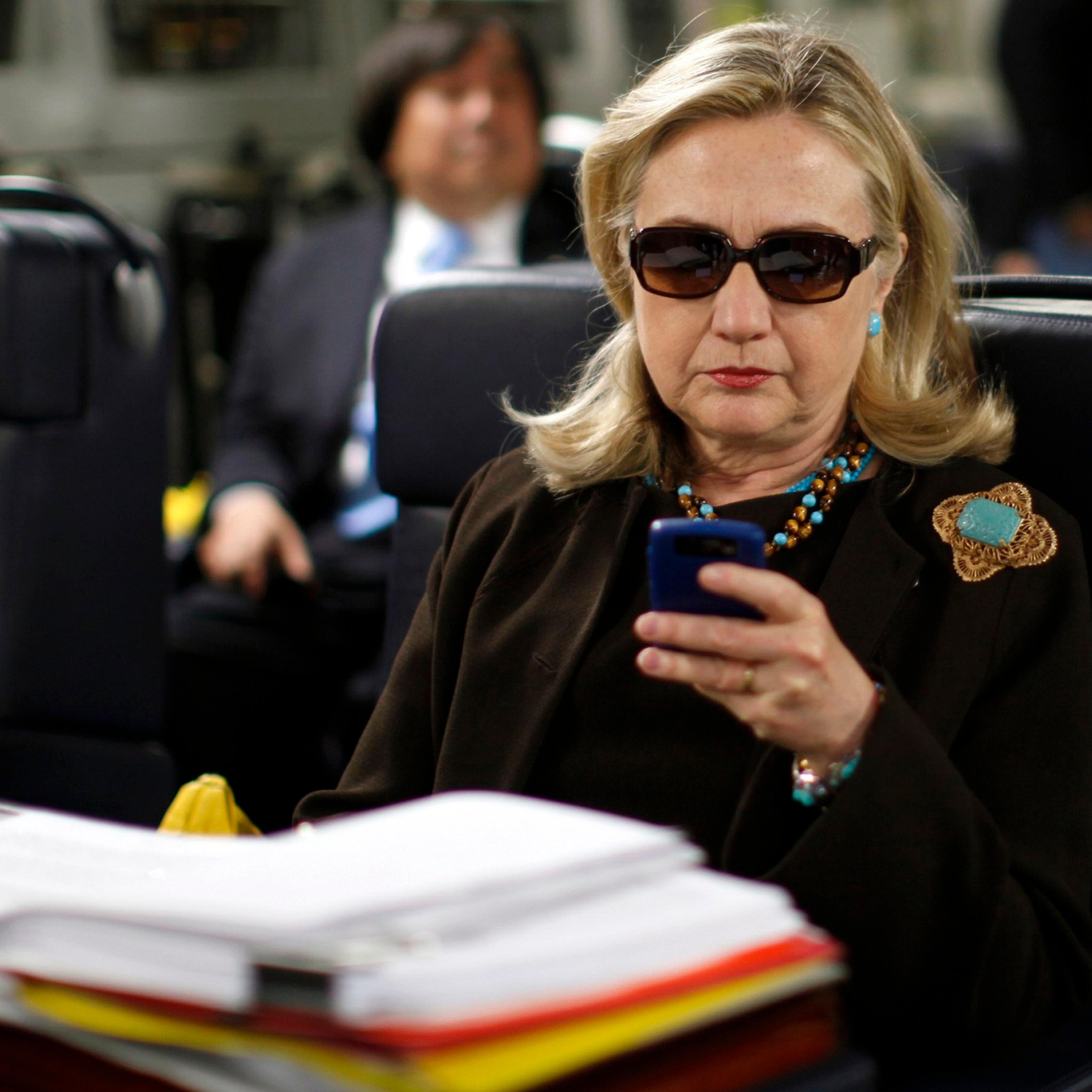 Former Secretary of State Hillary Clinton checks her PDA upon her departure in a military C-17 plane from Malta bound for Tripoli on Oct. 18, 2011.
