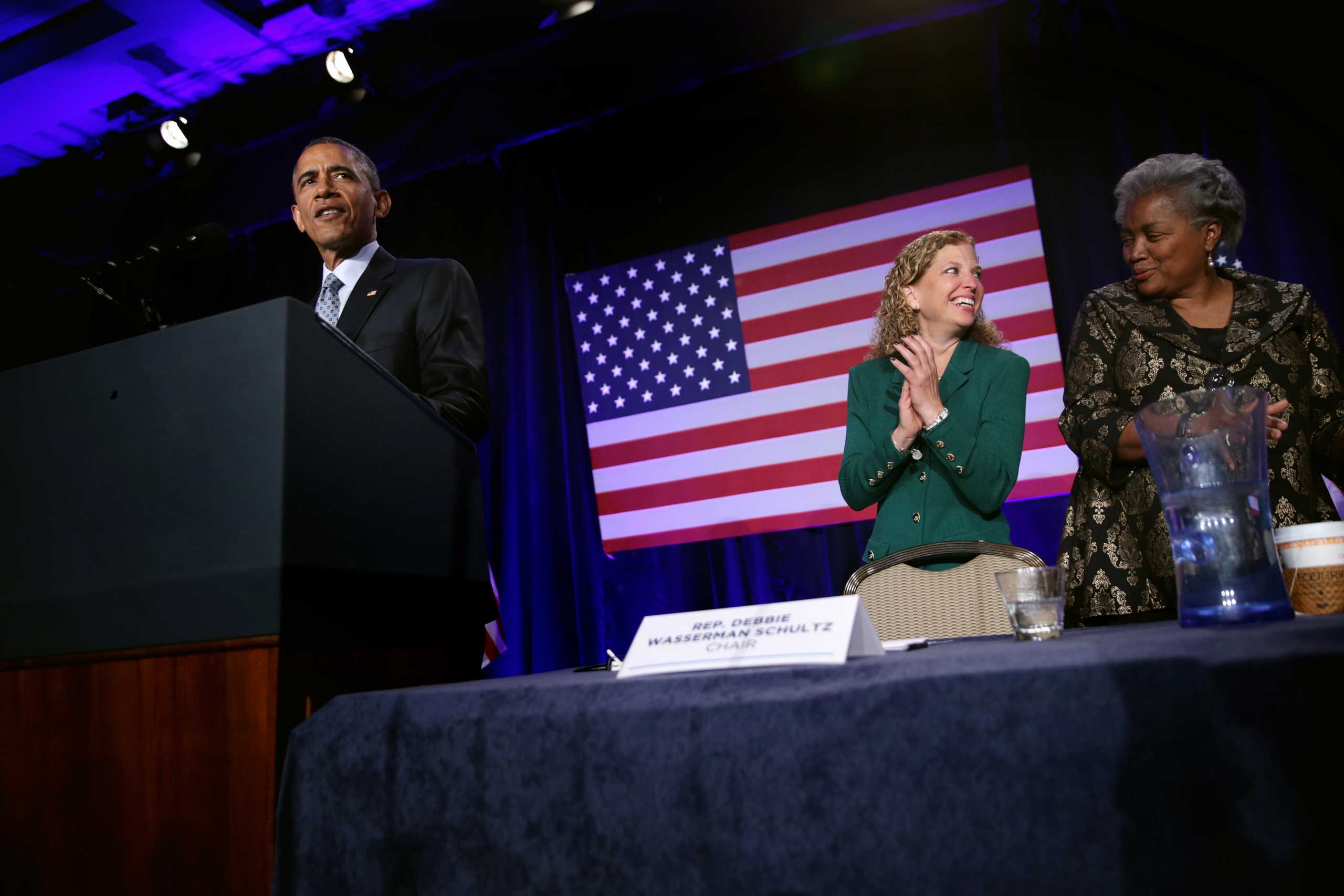 President Obama speaks as Democratic National Committee Chair and Rep. Debbie Wasserman Schultz and Vice Chair for Voter Registration and Participation Donna Brazile share a moment during the General Session of the 2015 DNC Winter Meeting, Feb. 20, 2015 