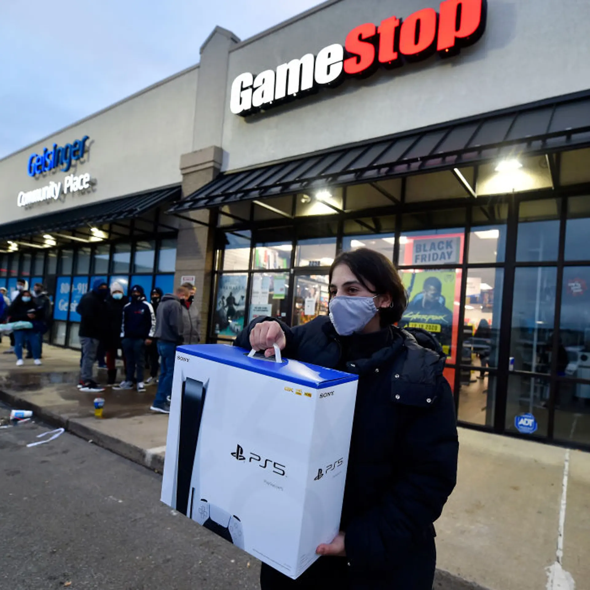 A man wearing a face masks leaves GameStop