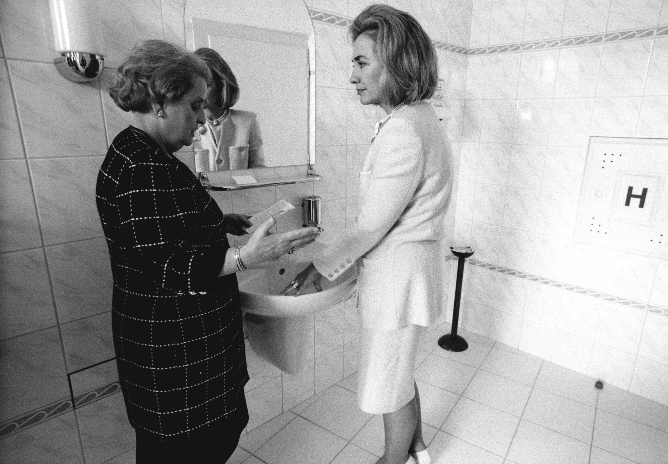 Secretary of state Madeleine Albright briefs First Lady Hillary Clinton in a ladies room during a trip to Prague, 1997. 